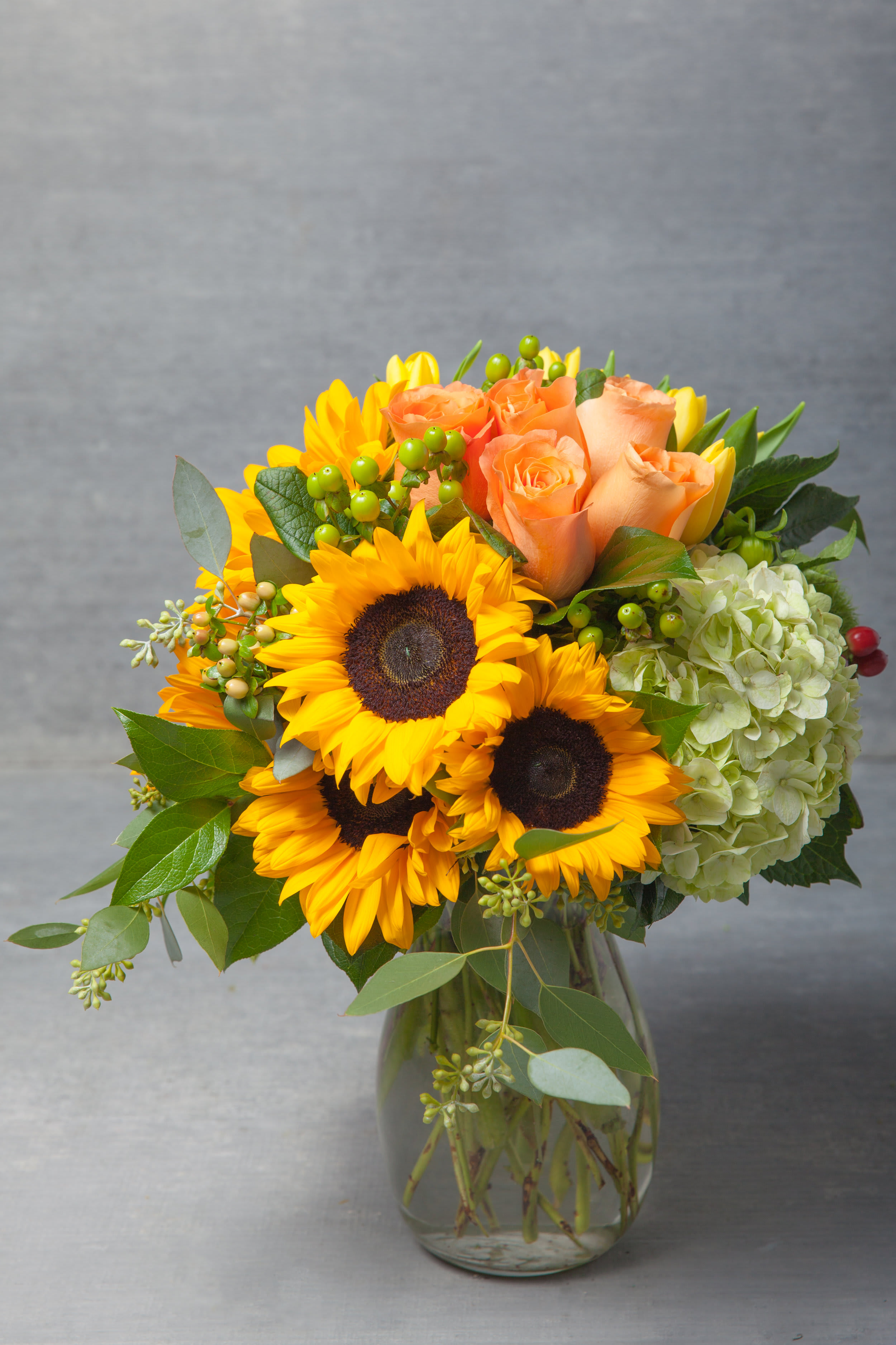 Parkside Pretty - This bountiful arrangement of sunshine creamcicle Roses, banana-toned Tulips, Hydrangeas and brilliant Sun Flowers.    