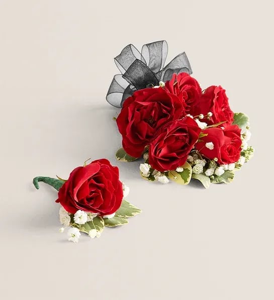 Corsage and Boutonniere Bundle: Red and Black - Comes with one corsage made with black ribbon, babies breath, and red spray roses, and a boutonniere made with a red rose, black ribbon, babies breath, and greenery. Bundle and save! Perfect for prom or homecoming.