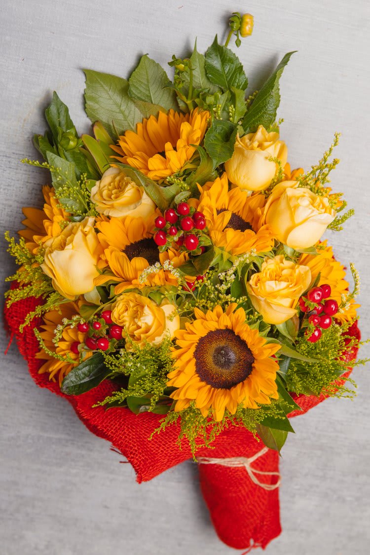 Duboce Triangle wrapped bouquet II - This red burlap wrapped bouquet features delightful Sunflowers, pale yellow Roses, red or green Berries... Take or make your custom bouquet with all floral varieties and colors. 