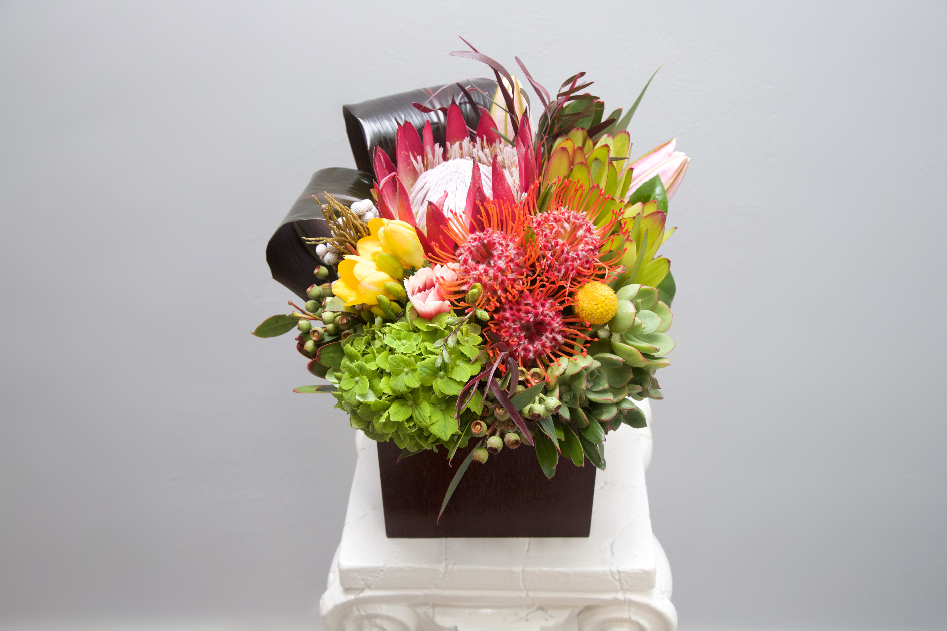Ocean Beach Blooms - This tropical blend of hot pink blooms, artistic banana leaves and succulents is certain to bring joy lifting anyone's spirit!