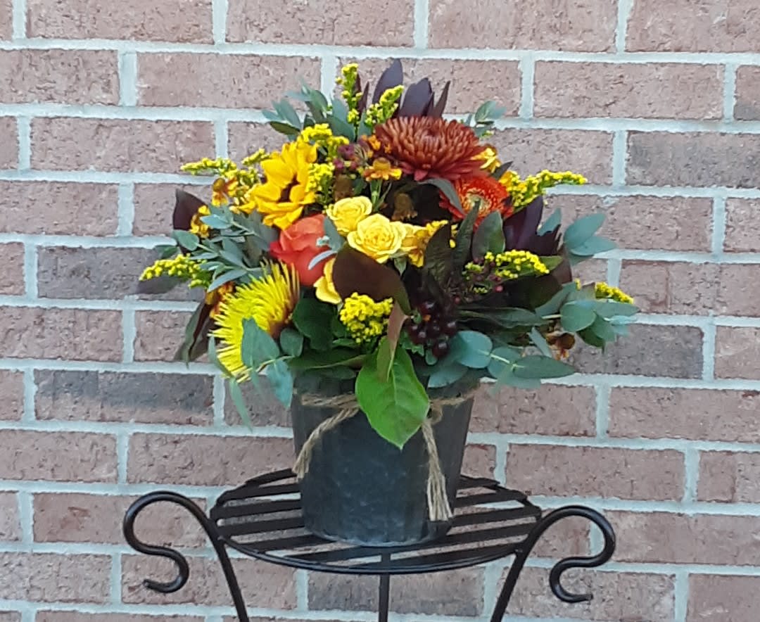 It's Fall Y'All! - A delightful collection of designer selected mixed fall blooms and greenery artfully arranged in a autumn tone tin or rustic basket.  Designer will choose container according to availability and seasonality.