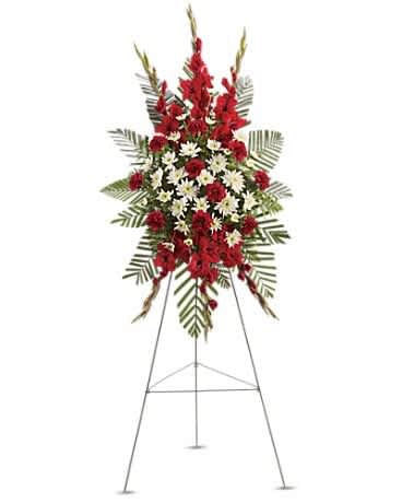Strength &amp; Solace Spray - Express your love beautifully and tastefully with this stunning spray of red and white floral favorites. An impeccable choice for the memorial service. The magnificent spray includes red gladioli, red carnations and white cushion spray chrysanthemums, accented with emerald palm and leatherleaf fern.