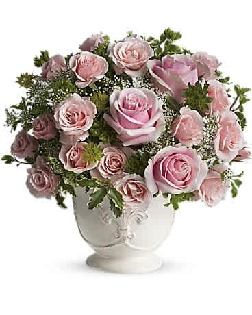 Teleflora's Parisian Pinks with Roses - Named after the most romantic city in the world, this pretty rose arrangement delivers romance ever so beautifully. Light pink roses symbolize femininity, elegance and refinement, especially when they are perfectly arranged in a white French country pot. Enchanting light pink roses and spray roses arranged with delicate Queen Anne's lace and greens are delivered in an exclusive ceramic container. C'est magnifique!