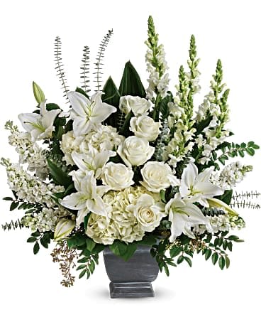 Teleflora's True Horizon Bouquet - Like the sun on the horizon, this pure white bouquet of hydrangea, roses and lilies offers hope and inspiration after the loss of a loved one. White hydrangea, white roses, white oriental lilies, white snapdragons, and white stock are arranged with huckleberry, seeded eucalyptus, spiral eucalyptus, green ti leaves, and lemon leaf. Delivered in a Modern Heritage Pot.