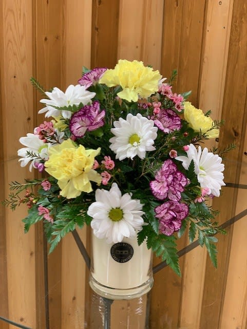 Candle Flower Arrangement - seasonal flowers  - Engraved Large Jar Candle with Optional Floral Arrangement – Haehn Florist &amp; Greenhouses  Send a unique gift that smells as wonderful as it looks! This large engraved jar candle is the perfect keepsake, burning for 145+ hours to fill any space with warmth and fragrance. Personalize your candle with a name, message, or special design—making it a one-of-a-kind gift for birthdays, anniversaries, memorials, or “just because.”  At checkout, please include any special instructions, such as your favorite candle color or the details you’d like engraved. Please note: engraving is completed before adding a flower arrangement.   Upgrade option: Choose the premium arrangement to have your candle beautifully displayed in a lush bed of fresh flowers—and this option includes a decorative lid. Standard engraved candles do not include a lid.   Available at: Haehn Florist &amp; Greenhouses 410 Hamilton Rd. Wapakoneta, OH 45895 ️ 419-738-8485  Give a gift that lasts long after the flowers fade—a fragrant, personalized candle that’s sure to be cherished.