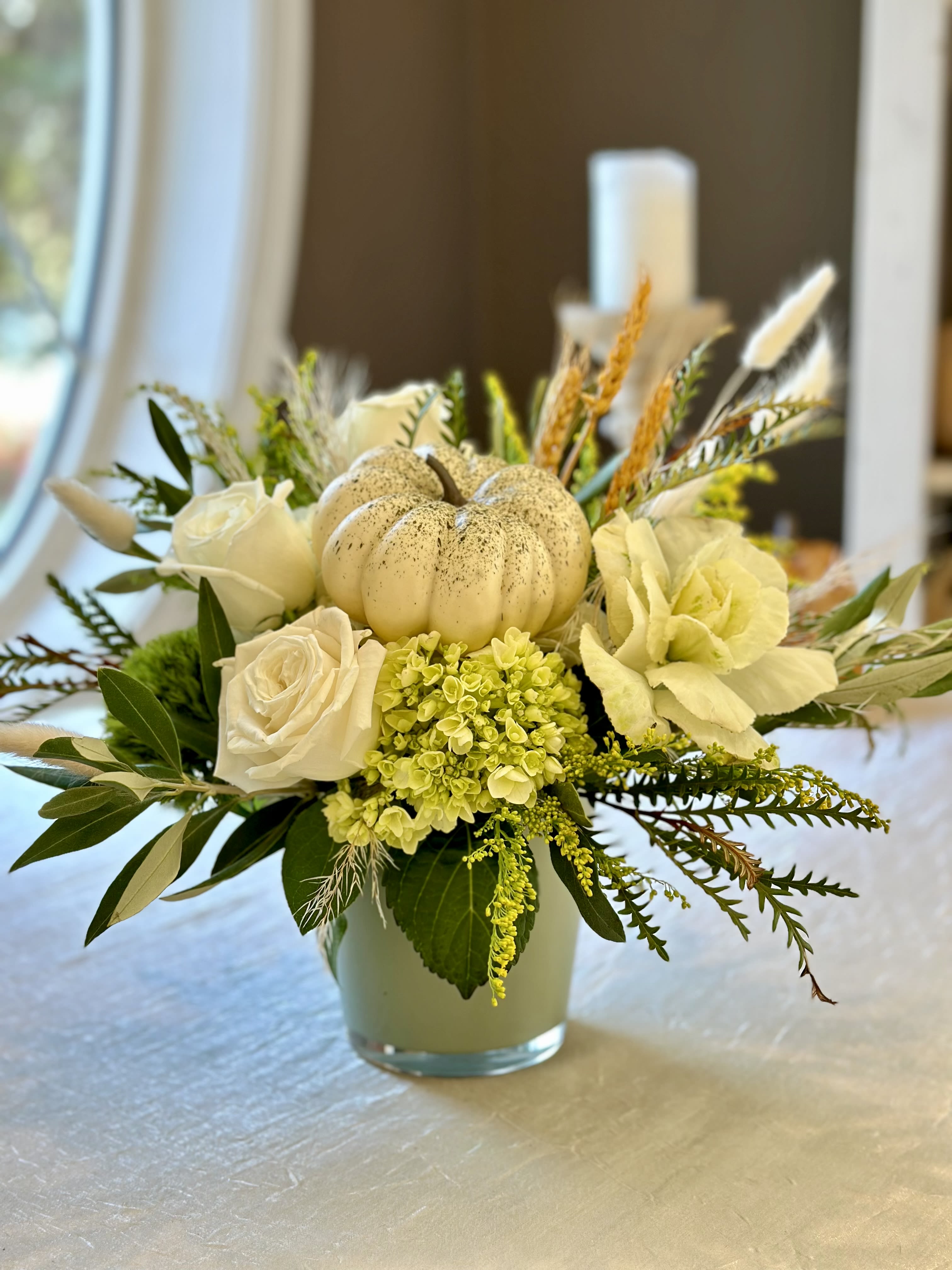 Gourd-eous Glam Arrangement - Muted fall fresh floral arrangement. Flowers include; roses, hydrangea, kale, mixed fall foliage's and a faux white gourd. Designed in a colored glass vase. FLOWERS &amp; COLORS MAY VARY! AVALABLE ONLY FOR LOCAL DELVERY!