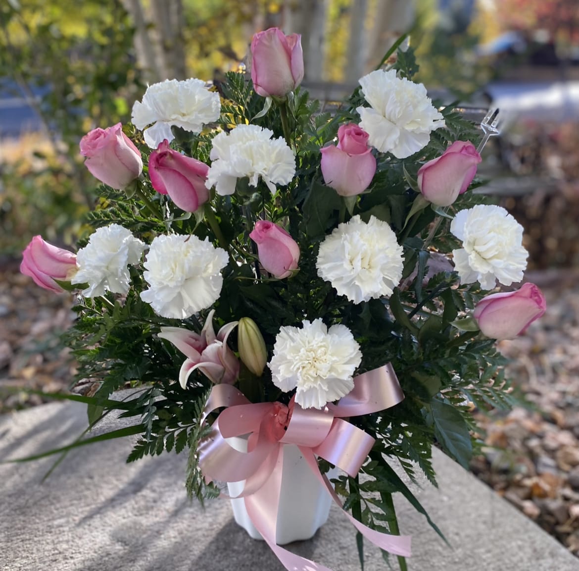 Heaven Sent - Heaven sent is a soft pink wonderland of grace and elegance to honor the life of loved one who will always be treasured. Soft pink roses and carnations, accented with lush greens are beautifully hand-arranged in a white pedestal container. 