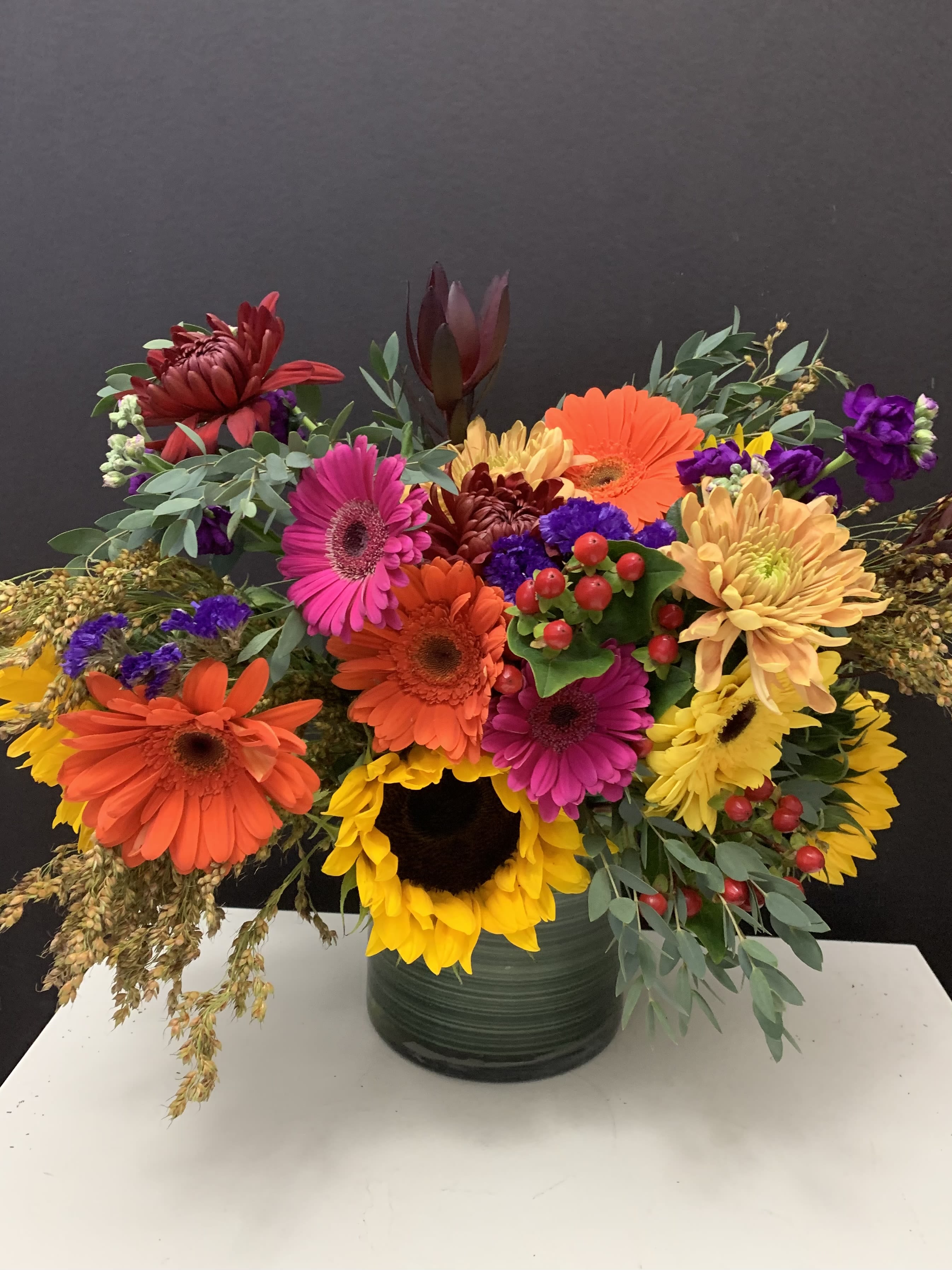 Fall Fantasy  - Sunflowers, Gerberas, green in 6”x6” glass cylinder vase 