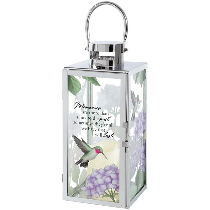 Lantern - 'Memories' (Silver w/ Hummingbird) Lantern - 'Memories' (Silver w/ Hummingbird) - Silver Lantern w/ Hummingbird - 'Memories are more than a link to the past sometimes they're all we have that will last.' Flameless LED candle lantern made with high quality chrome finish. Built-in automatic timer, 6hrs ON/18hrs OFF. 3 AAA batteries included. Weather friendly stainless steel. 57471 Approximately 5"W x 12"H