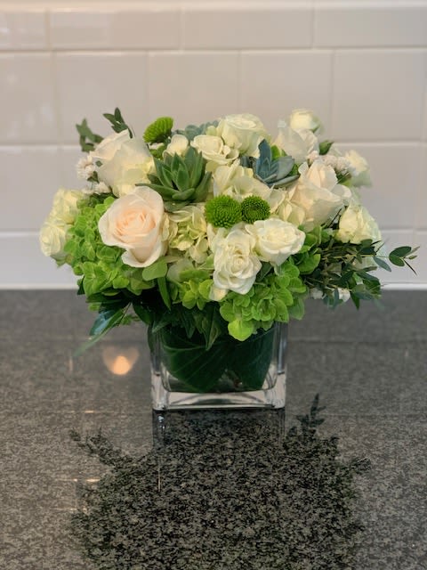 Southampton Gardens  - Discover serene elegance with our Southampton Gardens, a signature design from Designs By Mark Masone. Perfect for any occasion, this stunning piece is a testament to our expertise as a premier Southampton florist and Hamptons florist. The arrangement features a beautiful blend of creamy white roses, delicate light pink roses, and lush green hydrangeas, creating a soothing and sophisticated palette. A unique focal point is provided by the striking succulent, adding a modern touch and a hint of lasting beauty.  Our commitment to excellence ensures that when you order from Designs By Mark Masone, you receive the freshest and most exquisite flowers. We specialize in bespoke floral creations and offer reliable Flower Delivery in Southampton and Flower Delivery in Hamptons, NY. This arrangement is meticulously crafted in a chic square glass vase, making it a perfect centerpiece for a dinner party, a thoughtful gift for a loved one, or a stylish addition to your home or office.  Whether you're searching for a &quot;Southampton florist&quot; for a special event or need prompt &quot;Flower Delivery in Hamptons, NY&quot; for a last-minute gift, Designs By Mark Masone provides unparalleled service and design. This arrangement embodies the sophisticated and natural beauty of the Hamptons, making it a true standout. Let us bring the tranquil charm of the coast to your doorstep.