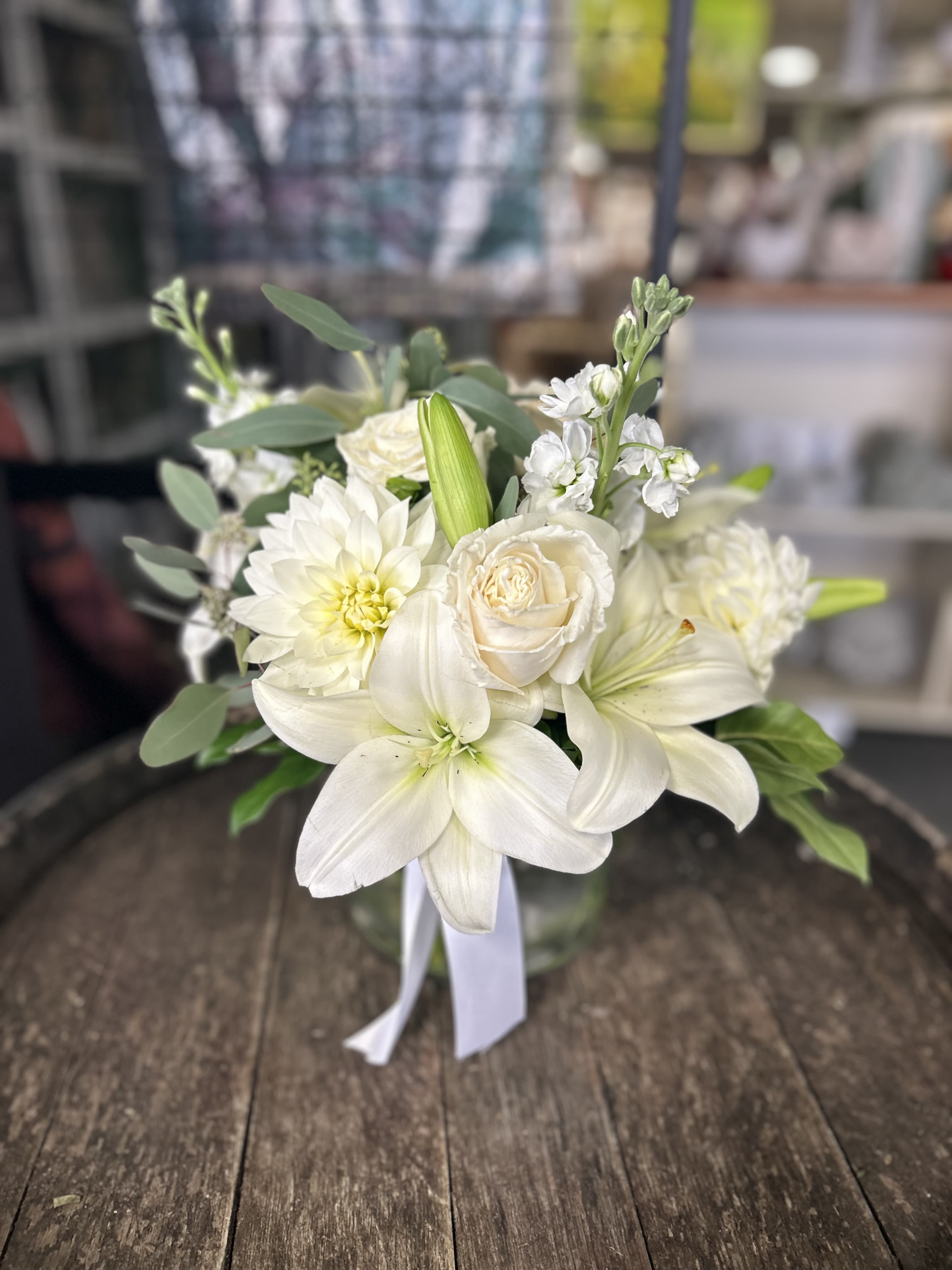 Elegance - This all white arrangement is made with lillies, roses, mums and more