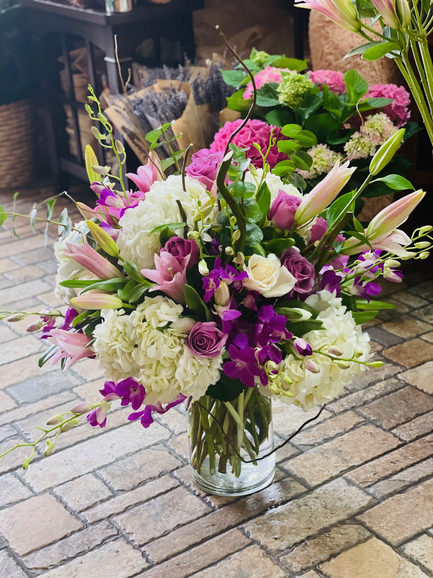 On Cloud 9 On Cloud 9 - Send a clear message of total love and admiration with this elegant and beautiful mix of hydrangeas, purple orchids and stargazer lilies in a large clear vase. Your partner will be absolutely speechless and on cloud 9 when they receive this over the top design!