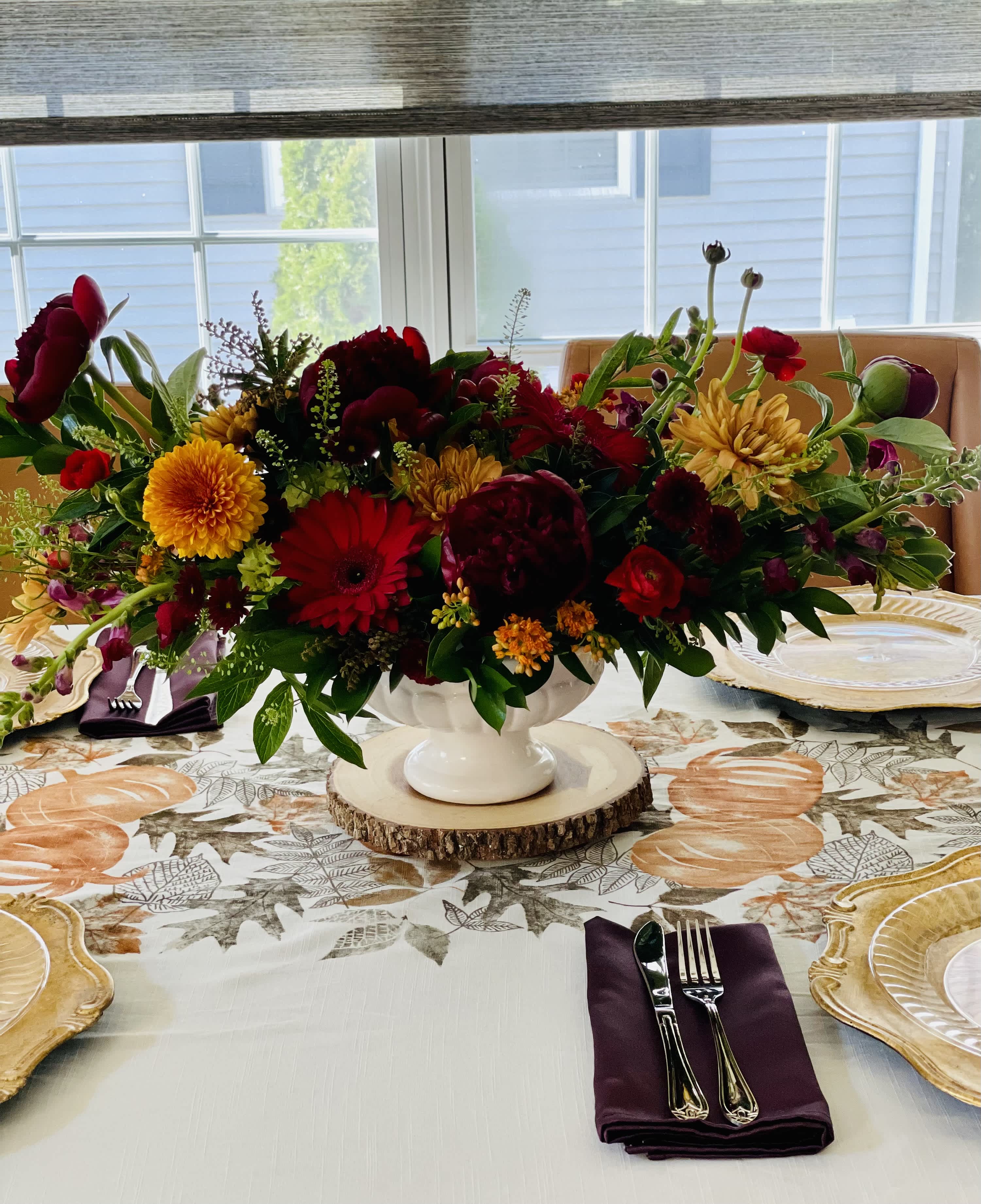 Harvest Night - Burgundy peonies, orange cremone, burgundy snapdragons, red gerberas, orange pomps, lepidium, burgundy mini carnations, assorted greenery in a white pedestal bowl
