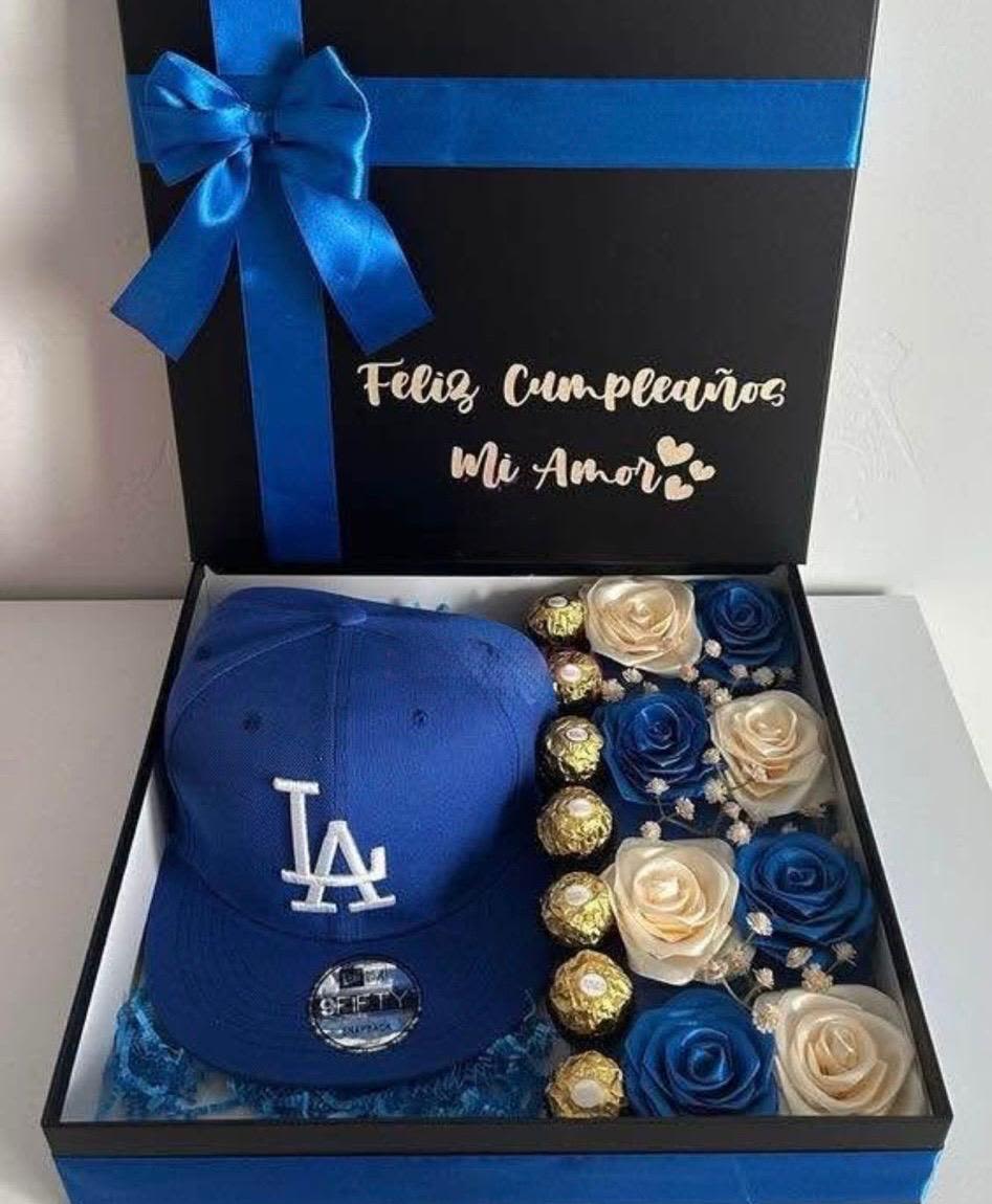 Caja con gorra y flores eternas. - Caja elaborada con flores eternas, chocolates y gorra.