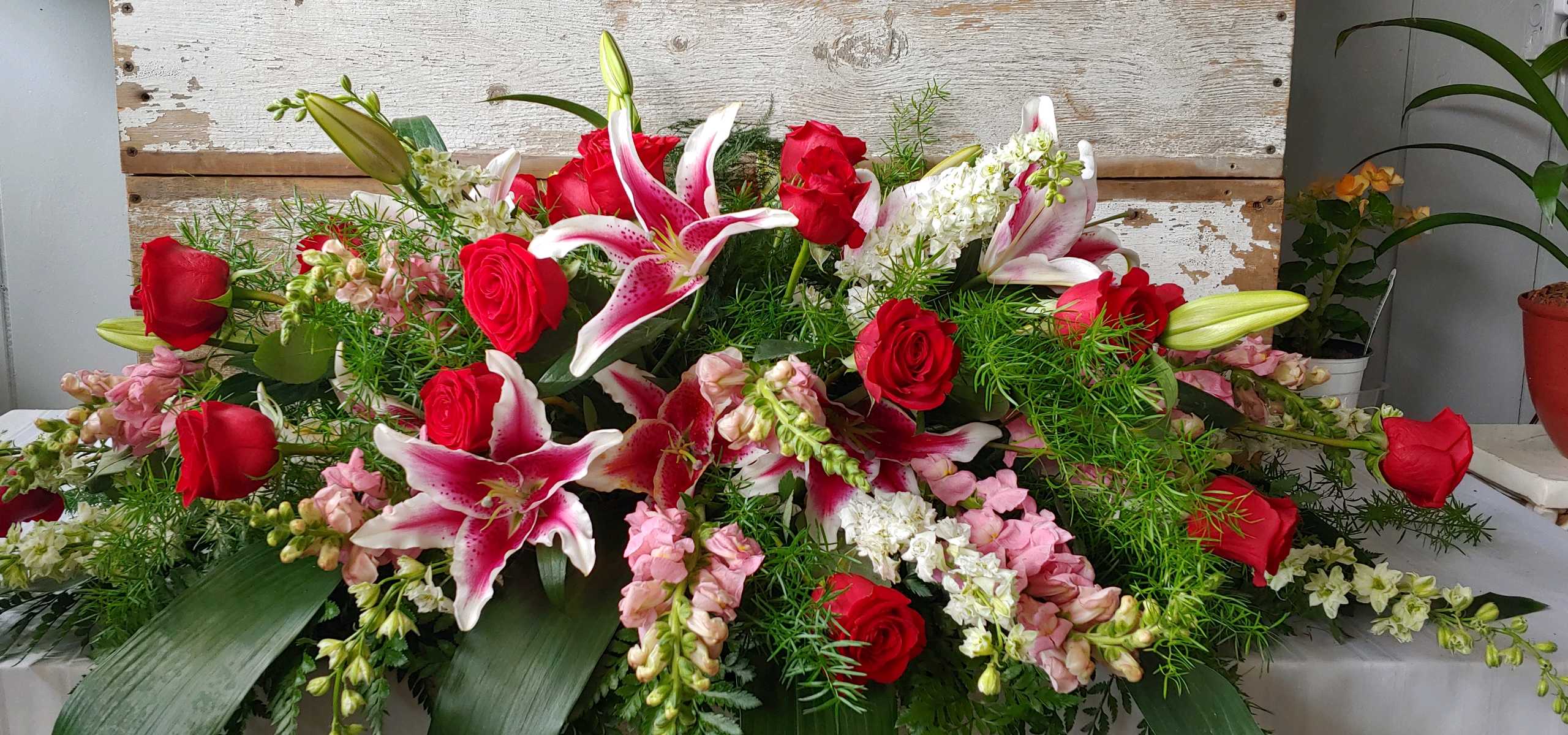 All our love All our love - Send all your love with this beautiful casket piece that incorporates stargazers red roses