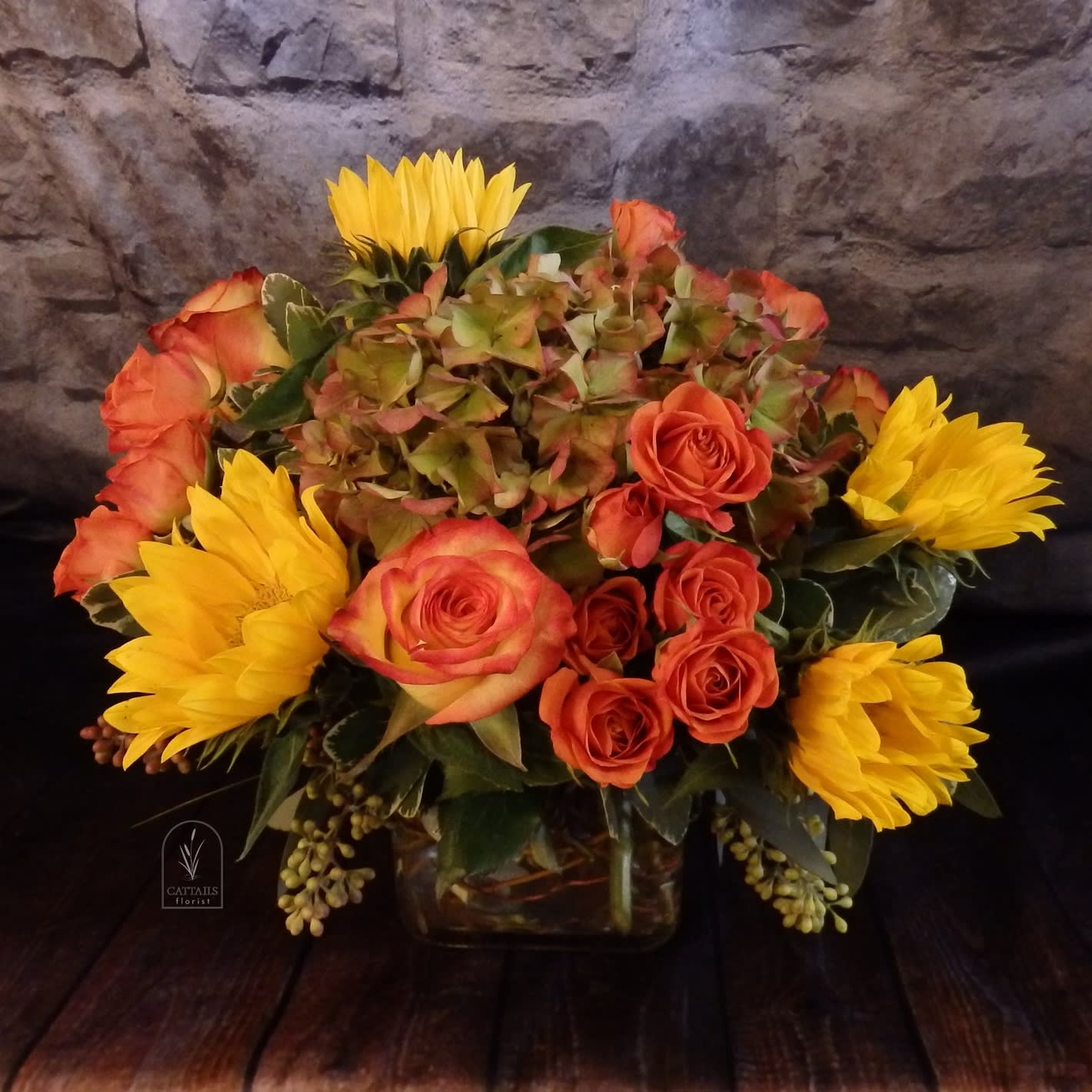 Wild Honey - &quot;Wild Honey&quot; is a warm and inviting arrangement featuring golden sunflowers, rich orange roses, spray roses and seasonal hydrangea, beautifully designed in a clear cube vase. A perfect touch of autumn charm for any occasion in Danville, CA.