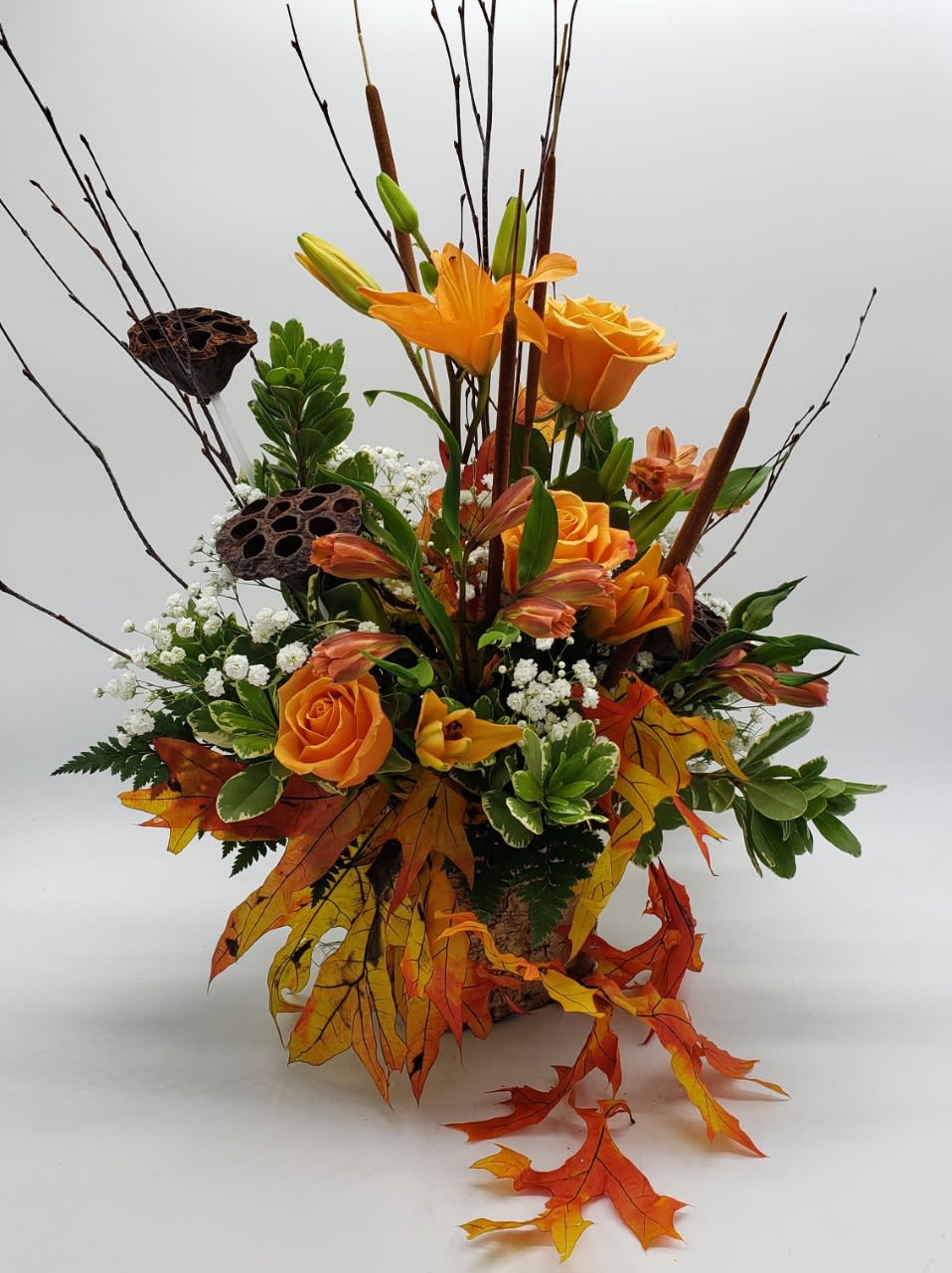 Burnt Orange Meadow - Imagine Walking Through a Meadow in the Fall and Gathering This Lovely Collection of Autumn Flowers, Pods, Cattails and Birch Branches. A Wonderful Expression of an Early Fall Display. The Arrangement is Designed With Orange Crush Roses, Orange Asiatic Lilies, Babies Breath, a Variety of Foliage, Preserved Oak Leaves, Lotus Pods All Designed in a Birch Bark Container. Although Summer is Fading Away, Enjoy the Wonderful Colors of the Impeding Autumn Season.