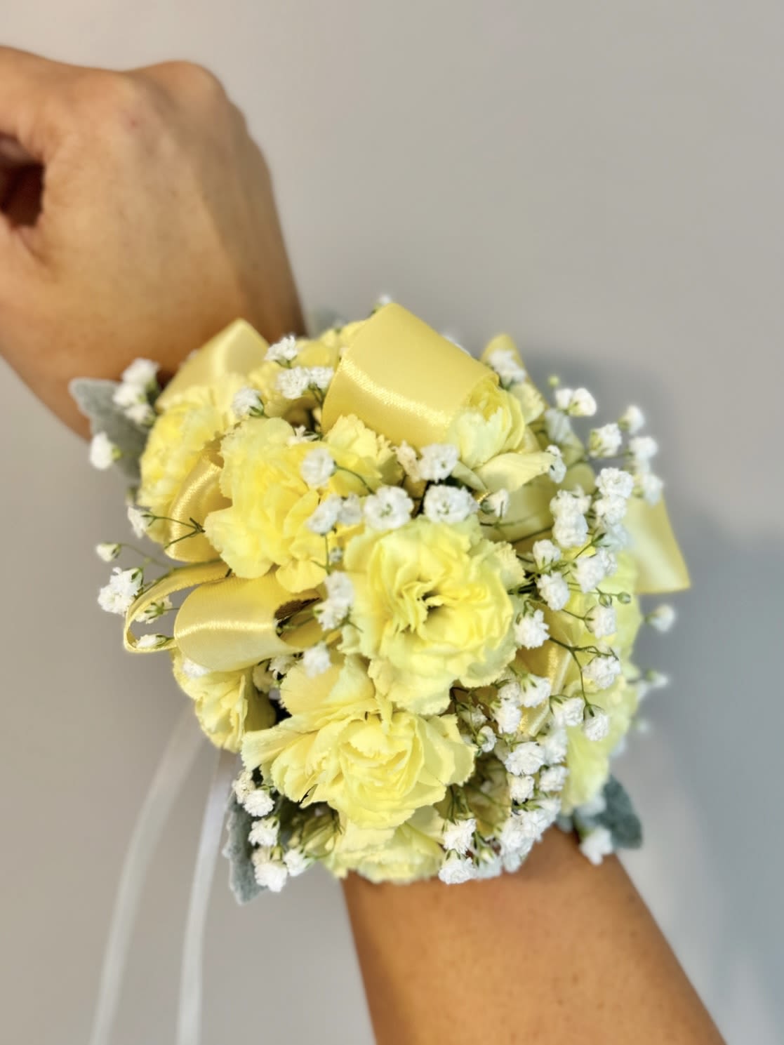 Corsage - A youthful and elegant design especially created by the Florist. Flowers are hand selected by the Florist. Perfect for prom, homecoming, and school dance.  Please specify preferred color theme in the Florist Instructions when ordering. Colors can be in White, Pink, Blue, Lavender, Orange, Red, Yellow, Green or No Preference.  Corsages come with 2 strings of pearls (as pictured).  We highly advise ordering at least 2 days in advance to ensure availability of supplies for the Color Selection.  If your event falls on a weekend, choose Friday delivery. Corsage will stay fresh for a few days if kept in a fridge. Delivered in a waterproof box with clear plastic lid.