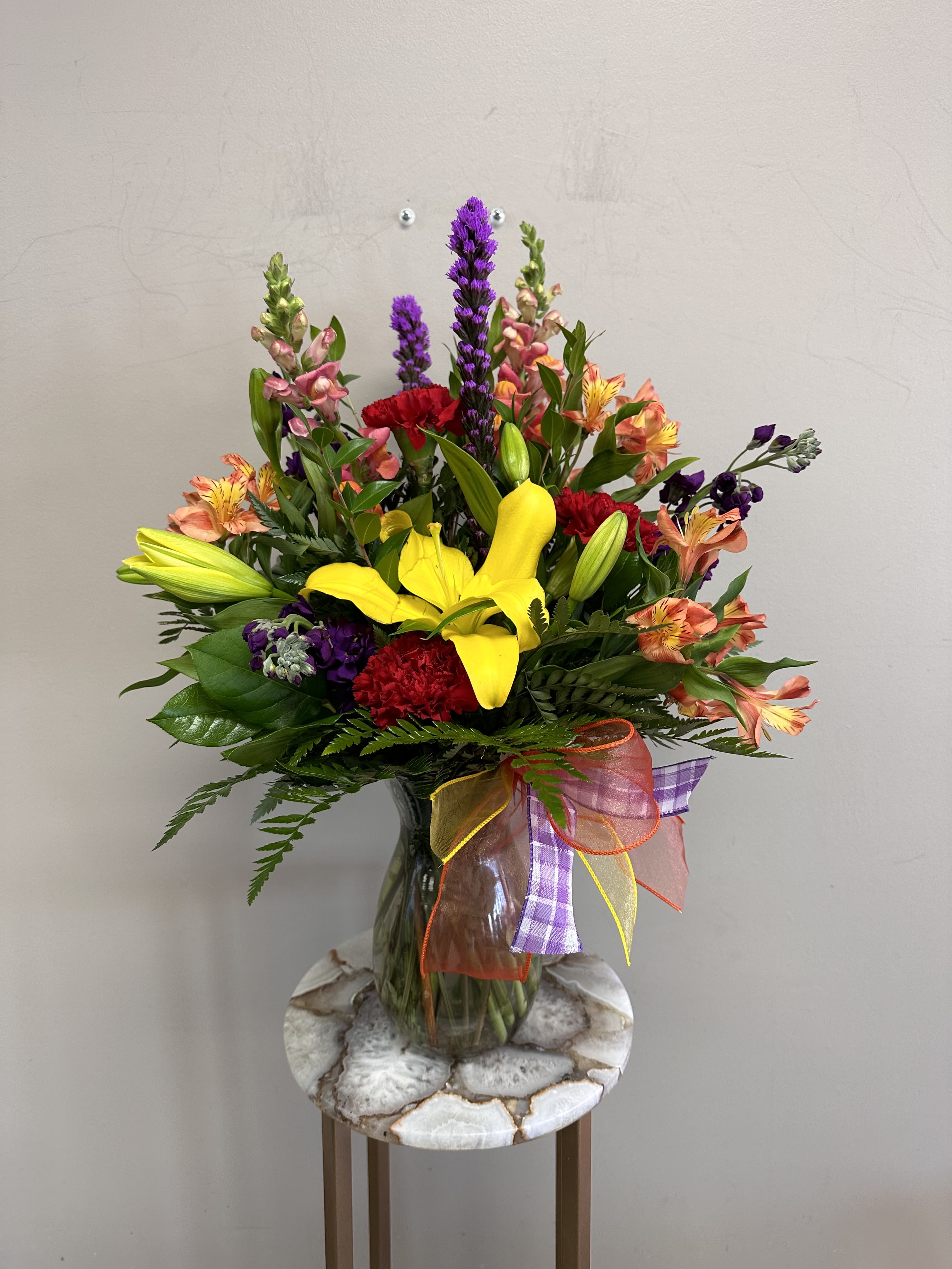 Sonoran Sunset Sonoran Sunset - A mix of orange snapdragons, purple larkspur, red carnations, yellow asiatic lilies and orange alstroemeria. Bring the Arizona sunset into your home!