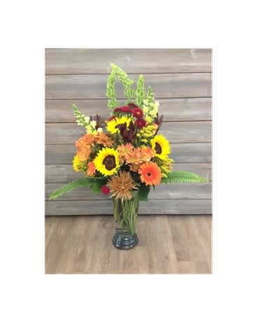 Fall Heights Bouquet - Classic fall colors arranged together for a tall bouquet that gives you a big show. Sunflowers, gerbers, fall mums &amp; daisies, safari sunset, solidago, mini carnations, bells of ireland, snap dragons, matsamuto asters.  Flowers and colors may be substituted depending on availability and season. Container may be substituted due to availability.   FCF-085