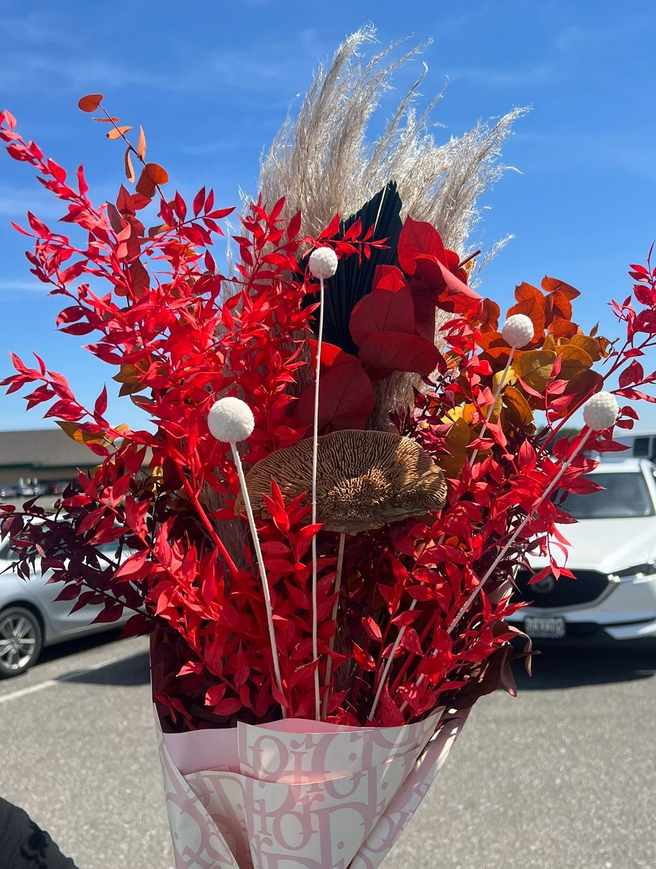 Tuscany Sun Tuscany Sun - Inspired by the golden fields and vibrant sunsets of Tuscany, the Tuscany Sun Dried Bouquet blends fiery red foliage, earthy textures, and soft pampas plumes into a striking, long-lasting arrangement. Designed for men and women alike, this bouquet offers bold beauty without the need for water—perfect as a modern gift or a timeless home accent.