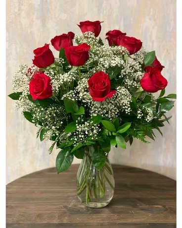 Dozen red roses Dozen red roses - Twelve long stem roses in a vase with greens and filler