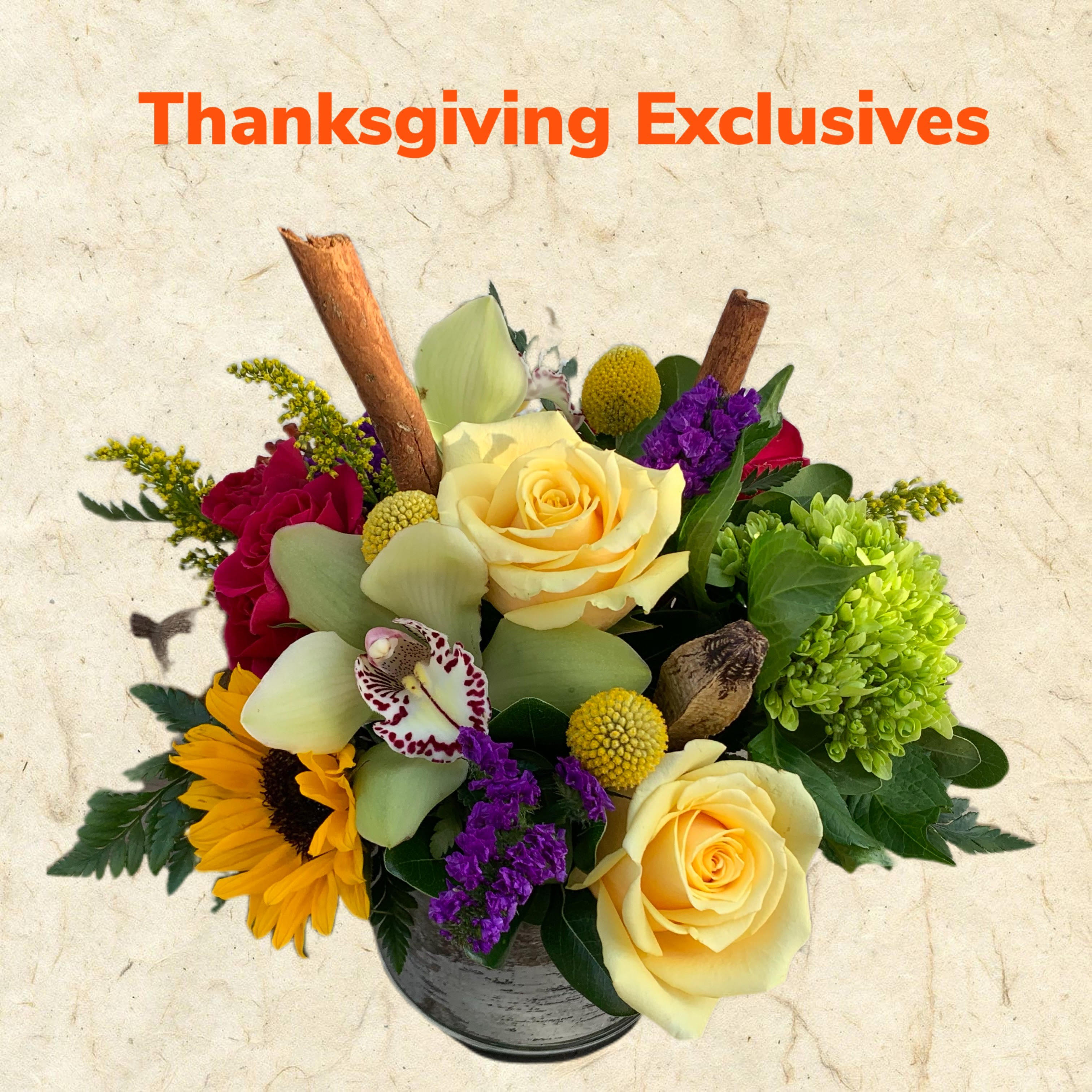 Thanksgiving Table Center in a Cylinder Thanksgiving Table Center in a Cylinder - Give your hostesses a beautiful centerpiece with a modern twisted. A mix of beautiful flowers in fall color scheme in a cylinder accented with Cinnamon Sticks to really make this feel and smell festive! * Please note this is a compact arrangement flowers and colors will vary based on what is in stock but the overall feel will remain the same. While right now due to COVID-19 we cannot guarantee a specific flower type, we always ensure your arrangement is beautiful & fresh arranged in a variety of colors!