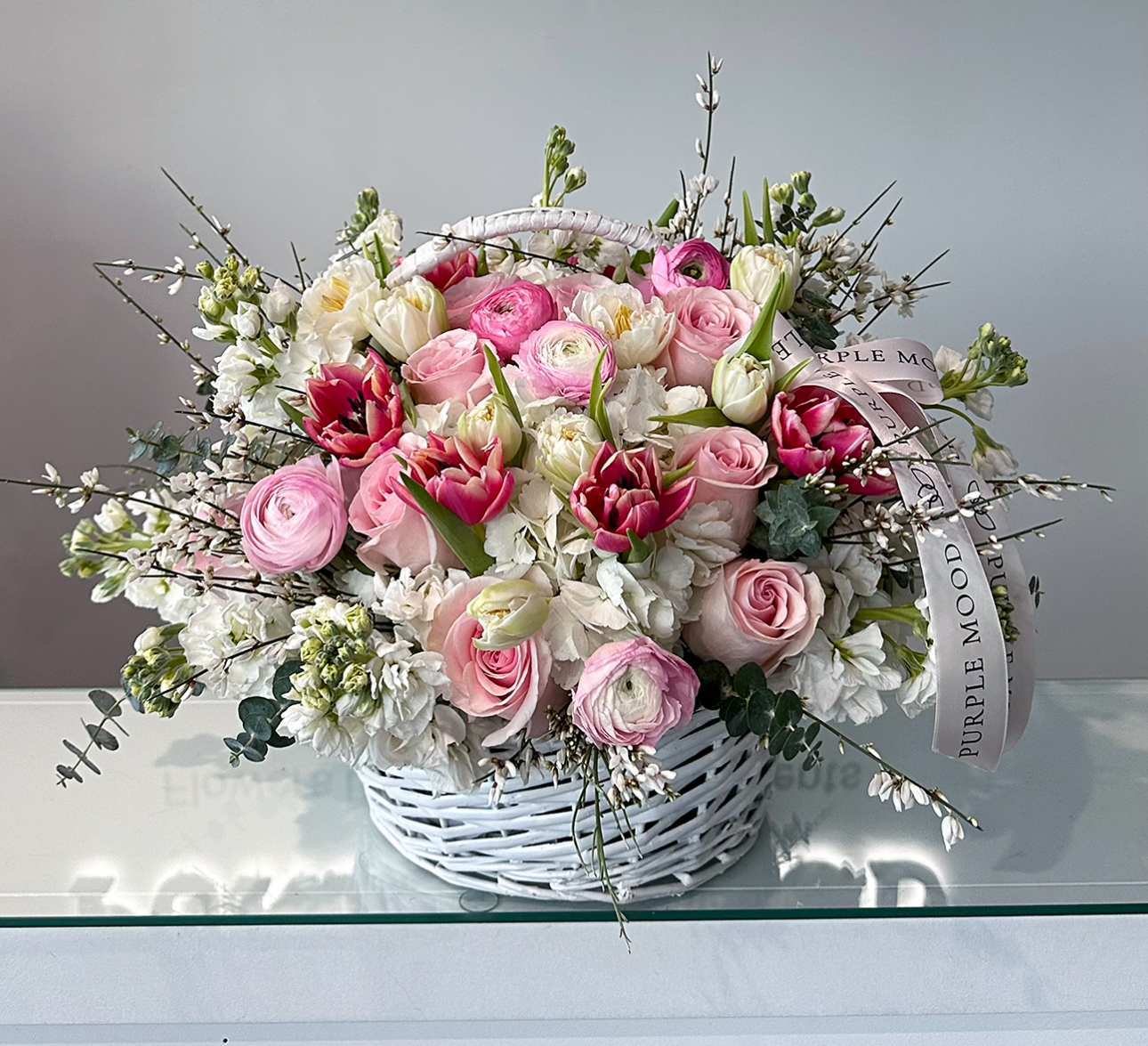 Pinkie Basket - Pinkie Basket Charming and full of life, the Pinky Basket is a radiant mix of soft blush tones, creamy whites, and playful pops of bright pink. Designed in a classic white wicker basket, this arrangement combines elegance with a touch of freshness — perfect for creating warm, joyful moments.      •    A rich blend of roses, ranunculus, tulips, and seasonal blooms     •    Presented in a reusable white wicker basket     •    Available in three sizes: Standard, Deluxe, and Premium     •    A thoughtful gift for celebrations, housewarmings, or simply to brighten someone’s day