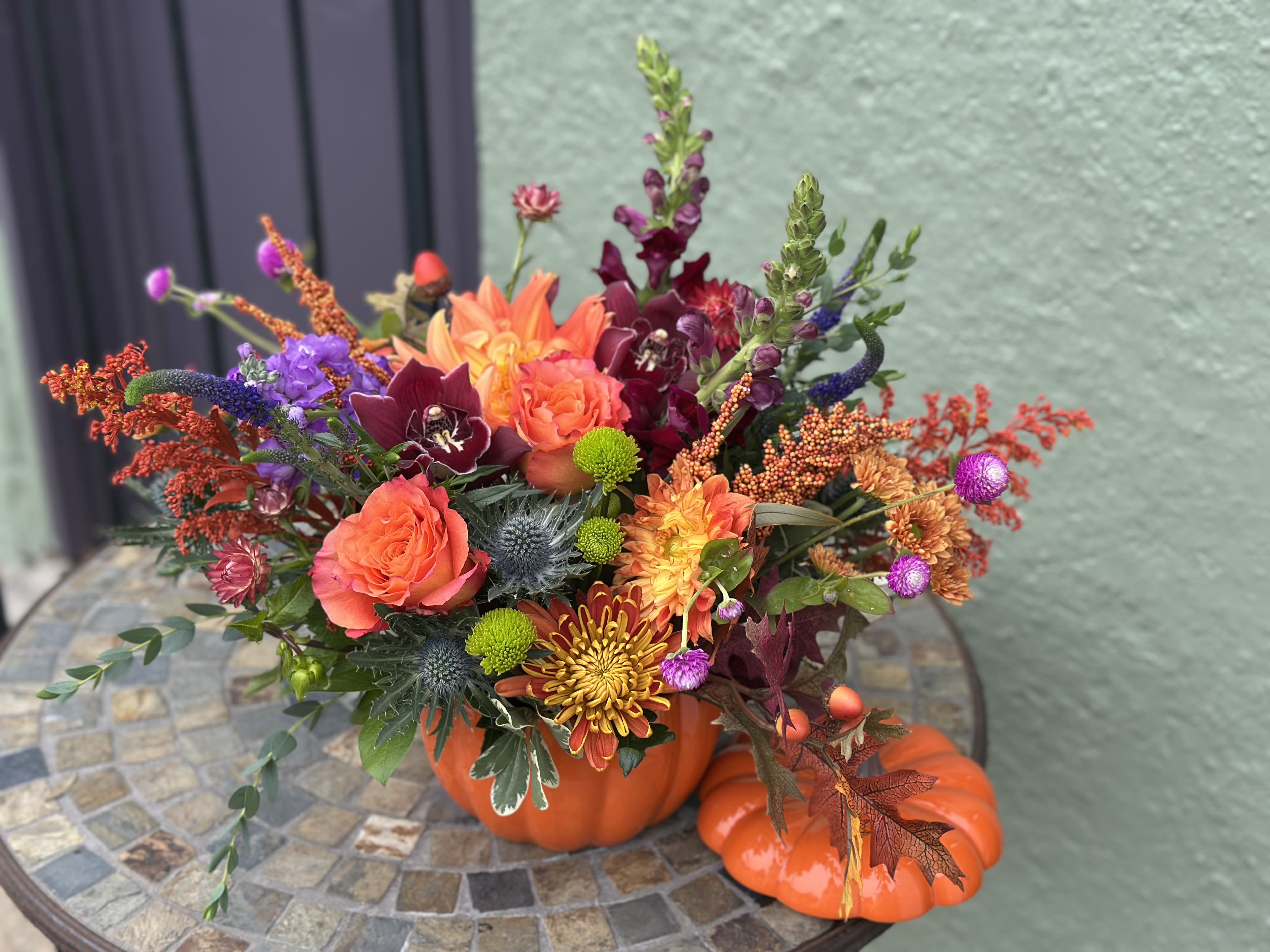 Petworth - Warm, vibrant, and full of seasonal charm, this pumpkin arrangement celebrates teh beauty of fall with fiery blooms, rich textures, adn rustic accents. Inspired by the timeless character of the Petworth neighborhood, it's the perfect centerpiece for gatherings, gifts, or simply brining a touch of autumn glow into your home.