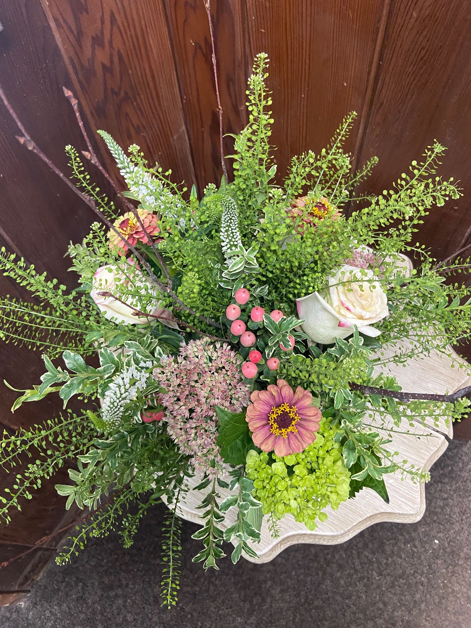 Woodland Fall Cube - Mix of sweetness roses, autumn joy (Sedum), peach hypericum berries, zinnias, veronica, and green hydrangeas in a 5” sq cube accented with birch branches.