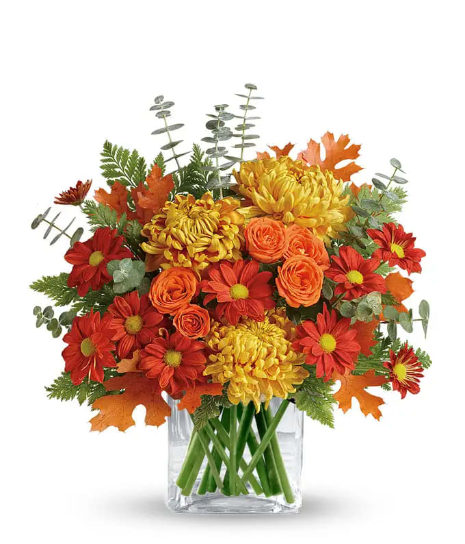 Fall Vase with Flair - Spray roses, daisy mums, cremones or mum balls with baby blue eucalyptus and fall leaves in a clear glass vase.  Sure to make her day! One sided arrangement