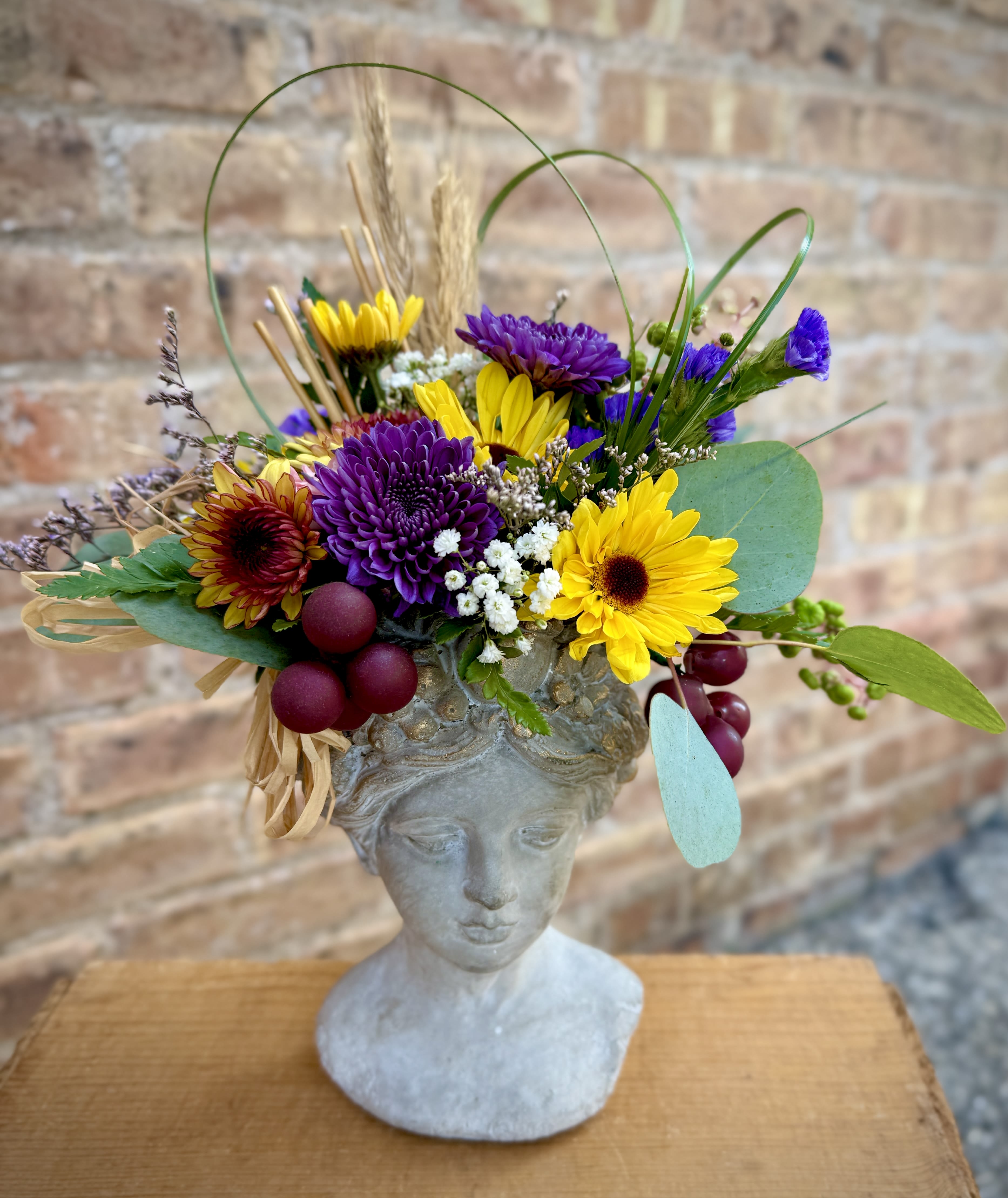 Autumn Goddess Autumn Goddess - This beautiful cement vase is filled with the warm colors of autumn. Approximately 9 x 12