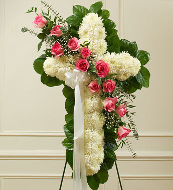 Peace and Prayers Standing Cross - Pink - Product ID: 91200   This beautiful floral tribute shows your faith, hope and love during this difficult time. This standing spray arrangement â in the shape of a cross â is created from fresh white mums, pink roses, spiral eucalyptus and more. Traditionally sent directly to the funeral home by family members or friends and displayed on a stand. Our florists use only the freshest flowers available so varieties and colors may vary.