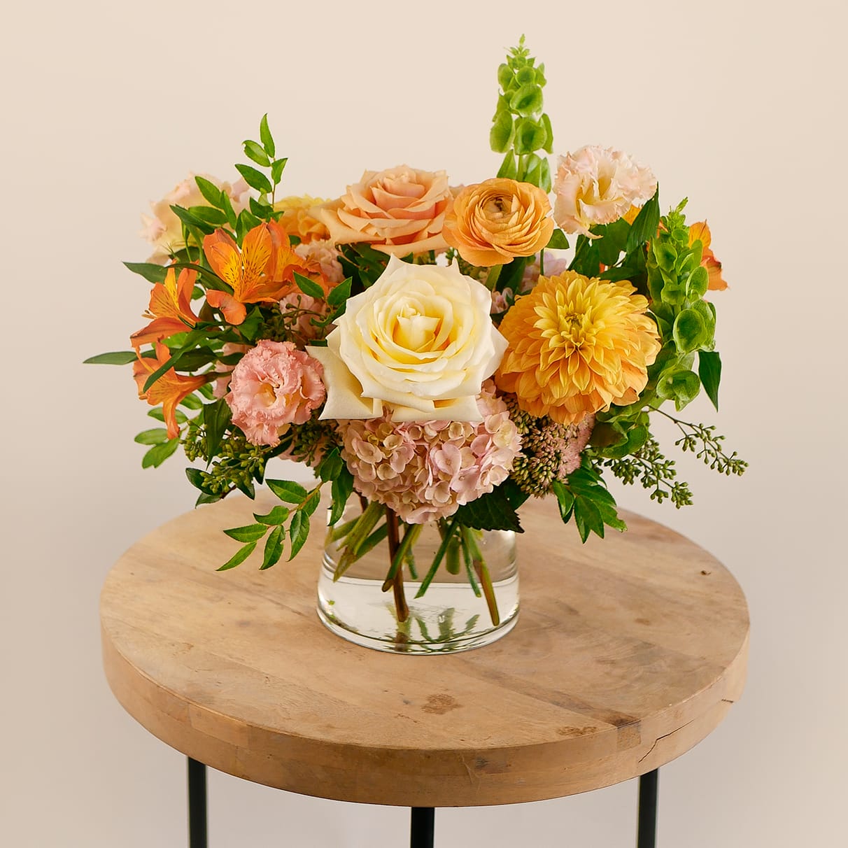 Golden Hour - Brighten any space with our Golden Hour arrangement! This petite yet lush design features creamy white roses, golden dahlias, peach ranunculus, soft hydrangea, and vibrant orange alstroemeria. Accented with seasonal greenery and fresh textures, this arrangement beautifully captures the warmth of fall in a modern glass vase. Perfect for birthdays, thank-you gifts, or to add a seasonal touch to your home or office, this handcrafted design is a thoughtful way to celebrate life’s special moments. Order today for fresh, artfully arranged flowers delivered across West Los Angeles.