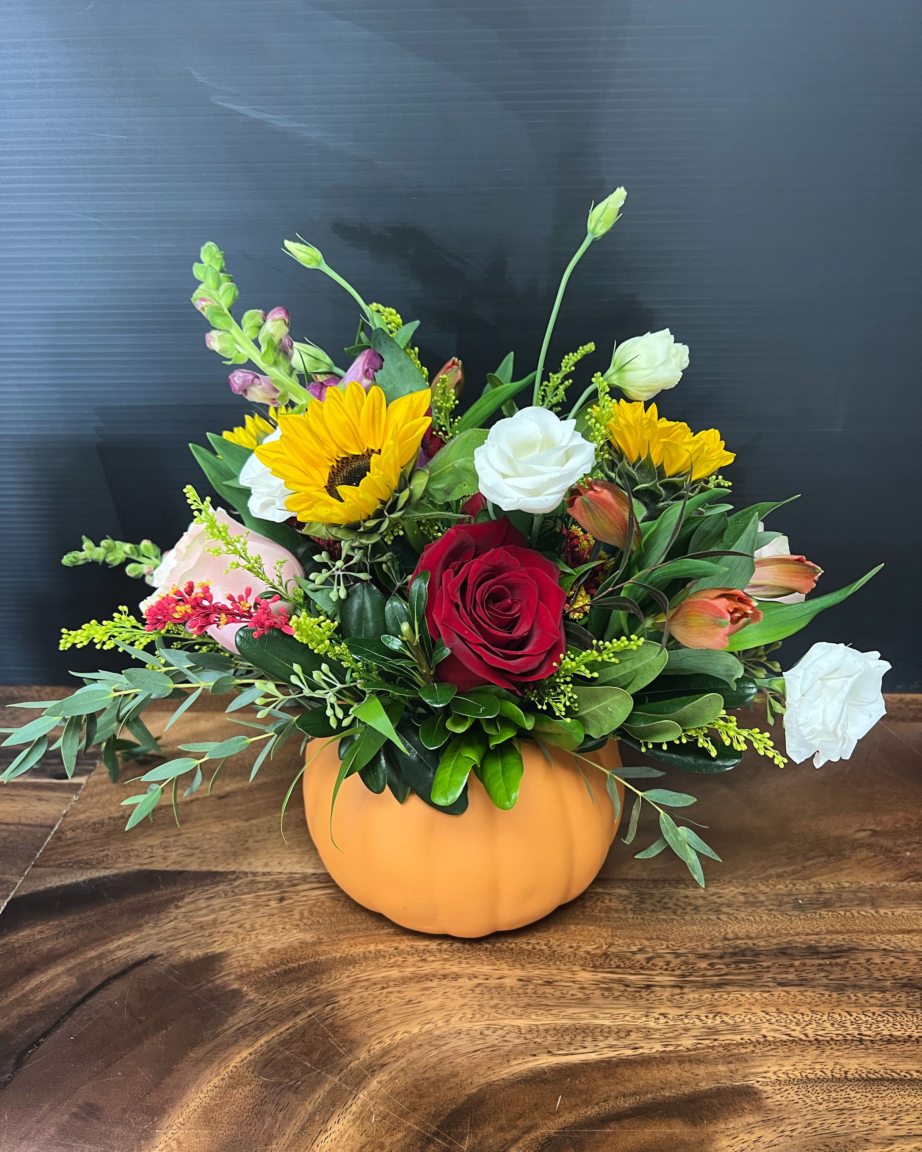 Pumpkin oh pumpkin  - Our Pumpkin centerpiece is perfect for adding a touch of color and charm to any setting, such as a dining table, a living room, or a bedroom. The pumpkin-shaped vase not only serves as a decorative piece but also adds a seasonal touch, making it an ideal choice for fall. Includes roses, sunflowers, snapdragons and many other seasonal blooms 