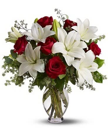 Teleflora's Baby Be Mine - The look of love plus the scent of love. What woman could resist the heavenly fragrance of lilies along with the beauty of passionately red roses? Silly question. The fragrant bouquet includes white Asiatic lilies and red roses accented with fresh greenery delivered in a classic clear glass vase. Bouquet is approximately 19â W X 20 1/2â H. This item is hand-arranged and delivered by a florist.