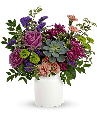 Teleflora's Hidden Garden Bouquet - This neutral matte white keepsake lends an organic feel to this extraordinary jewel-toned bouquet of blooms and succulents! Lavender roses, soft peach carnations, purple sinuata statice all pair organically with an echeveria succulent. Delivered in a matte white Savannah Jar.