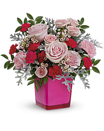 Teleflora's Pink Empowerment Bouquet - Pinktastic! Pour on the feminine charm with this gorgeous glass cube brimming with roses. Later, the vase doubles as a votive candleholder! This pretty arrangement features pink roses, pink spray roses, miniature hot pink carnations, white waxflower, silver lace dusty miller and huckleberry. Delivered in a Color Splash Cube.