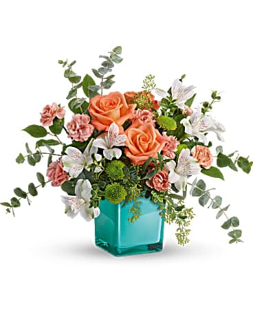Teleflora's Sunset Splash Bouquet - Inspired by the warm peach skies and crystal blue waters of a tropical sunset, this fun-filled rose bouquet adds a splash of happiness to any occasion! This delightful arrangement features peach roses, white alstroemeria, peach miniature carnations, green button spray chrysanthemums, spiral eucalyptus, seeded eucalyptus, oregonia, and lemon leaf. Delivered in an Aqua Color Splash Cube.