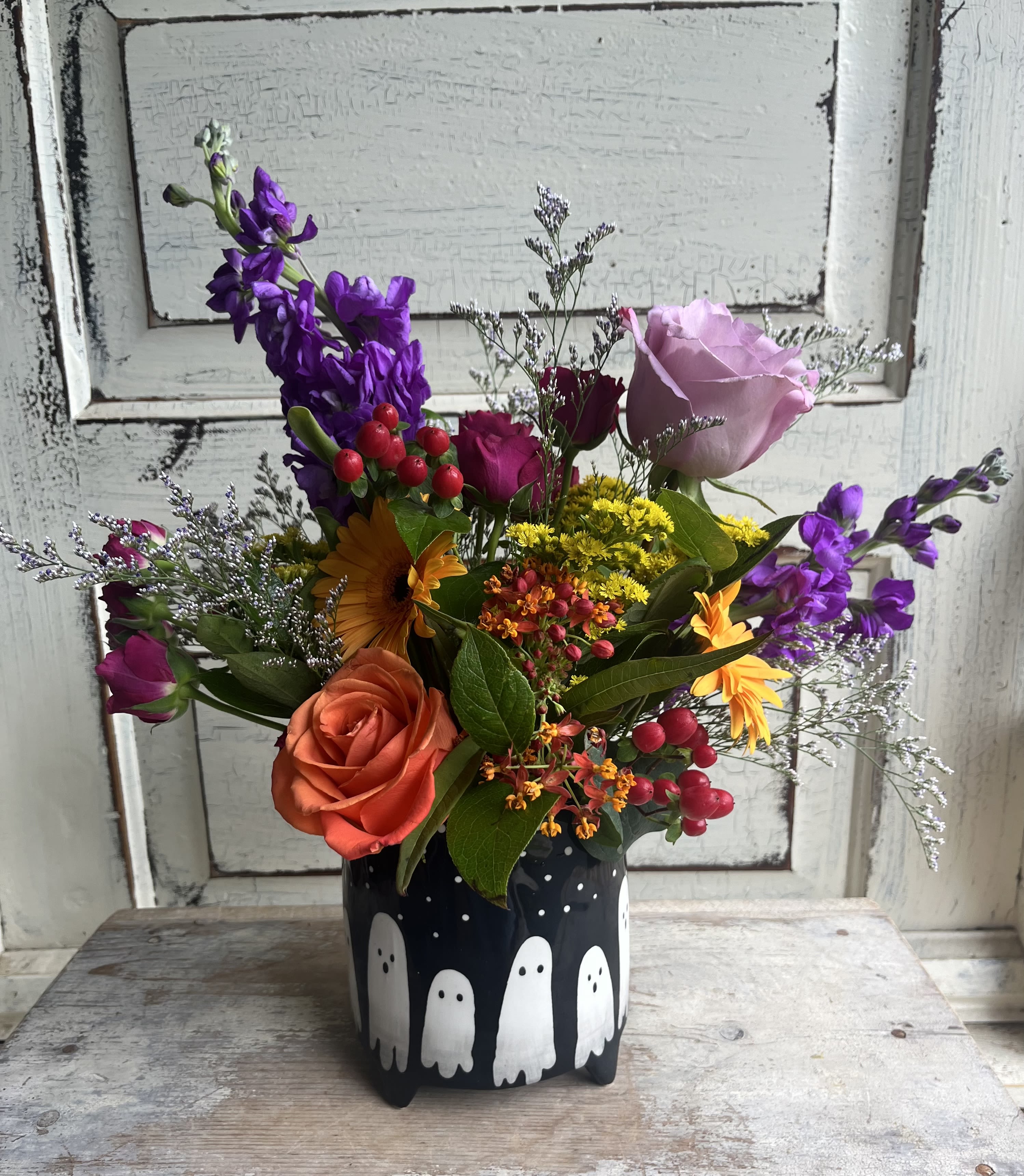 Spooky Season - Assorted bright blooms, fillers and an accent of foliage fill an adorable Halloween-inspired ceramic bowl. This design sets a festive mood and make a great table centerpiece. The deluxe version is the same container with more blooms.