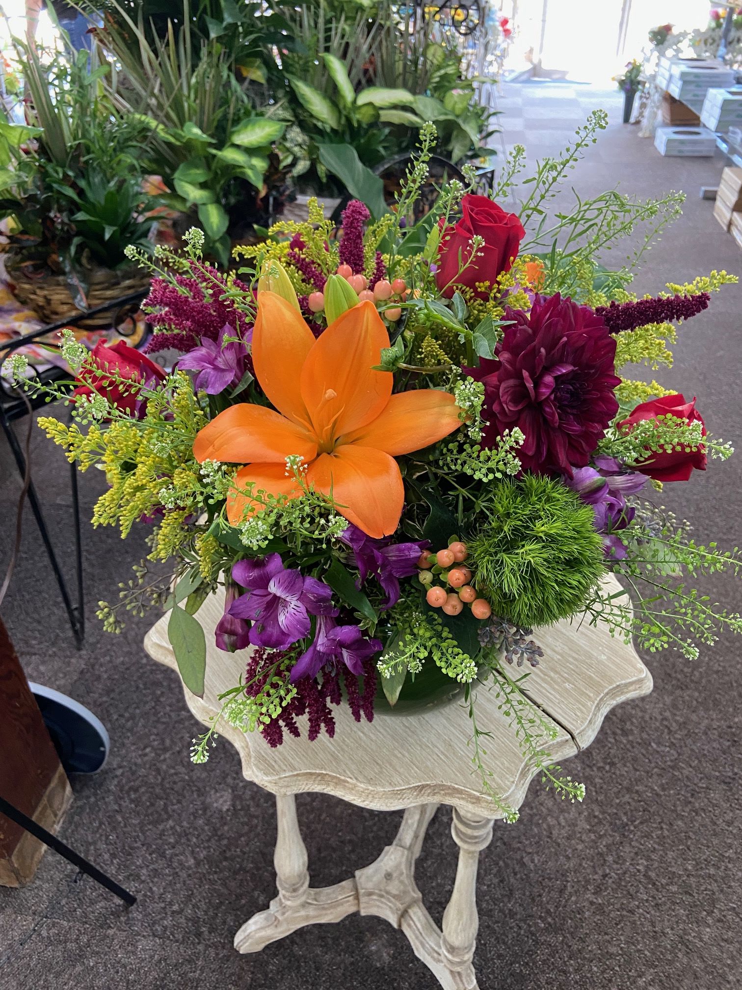 Vibrant Fall Bowl - A mix of fall flowers makes a statement! Dahlias, Freedom roses, amaranth and a mix of berries and fall flowers in a leaf lined bowl.