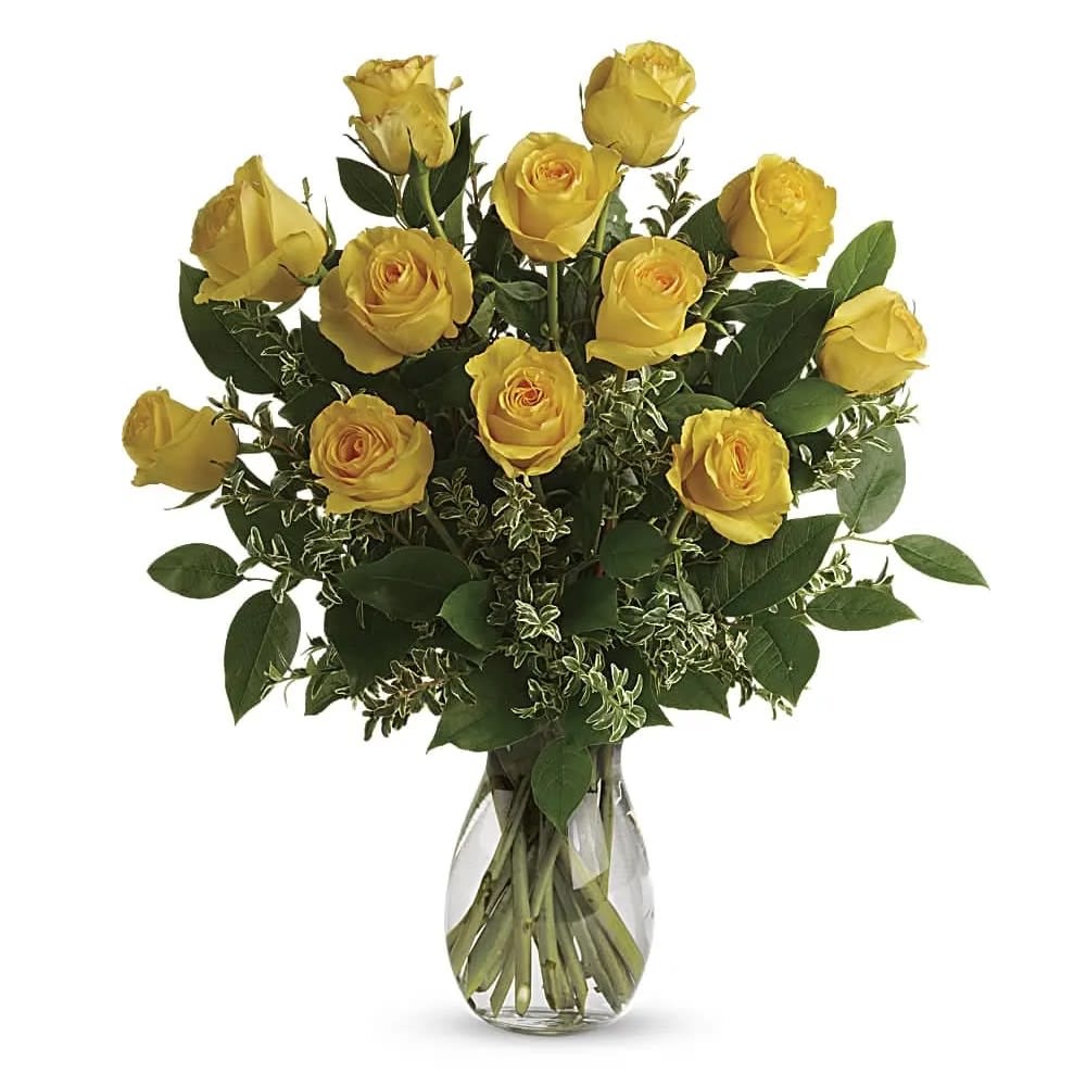 Say Yellow Bouquet - Here comes the sun! Say hello to a happy day with this grand bouquet of a dozen yellow roses and fresh greens in a graceful glass vase. This sunny arrangement features 12 yellow roses with oregonia and lemon leaf. Delivered in a glass jordan Vase.