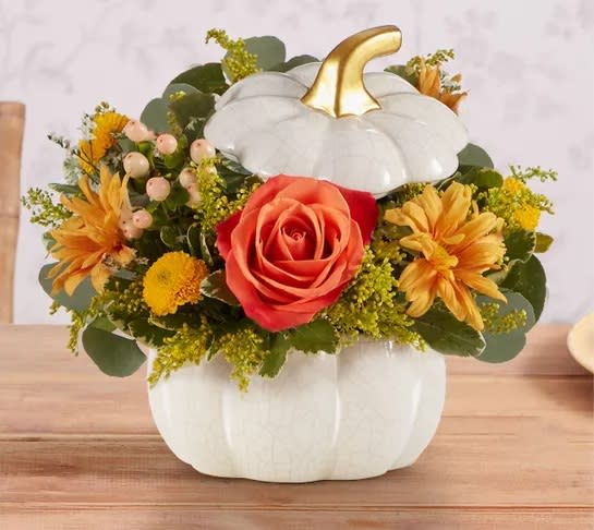 Autumn White Pumpkin - A plentiful mix of blooms gives our autumn arrangement an undeniable charm. Loosely gathered with pops of orange and yellow, it’s the perfect contrast to our modern-styled pumpkin. Featuring a white satin finish, crackle detail and rich golden accents, this harvest-inspired container is perfect for repurposing.
