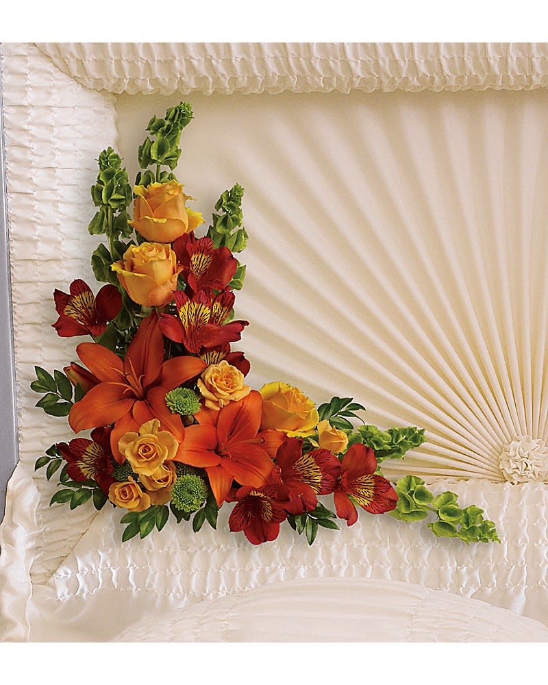 Island Sunset Casket Insert - Featuring stunning roses, lilies and alstroemeria, this sunset-inspired arrangement is a bright, heart-warming tribute to the special person who lit up everyone's lives. This beautiful arrangement includes light orange roses, light orange spray roses, orange asiatic lilies, red alstroemeria, green button spray chrysanthemums, bells of Ireland and huckleberry.