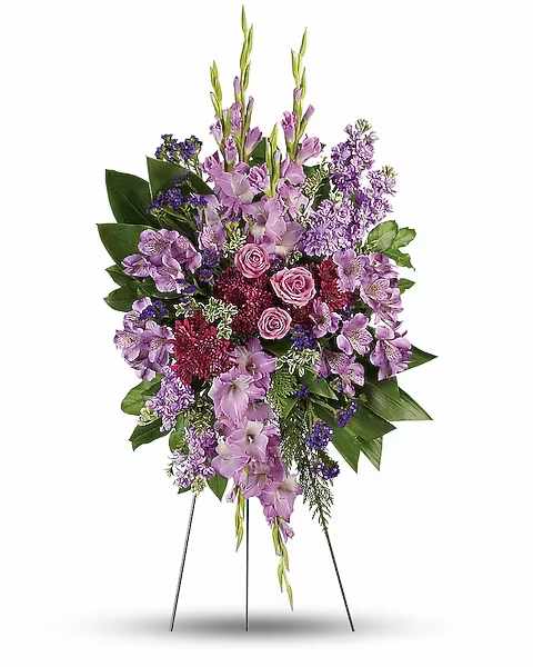 Lavender Reflections Standing Spray - Take a walk through the garden of memories with this lush spray of lavender and purple blooms, accented with fresh green ti leaves. It's a joyful expression of sympathy sure to be appreciated. This regal spray includes lavender roses, lavender alstroemeria, lavender gladioli, lavender stock, purple cushion spray chrysanthemums, purple sinuata statice, green ti leaves, flat cedar, oregonia and lemon leaf.