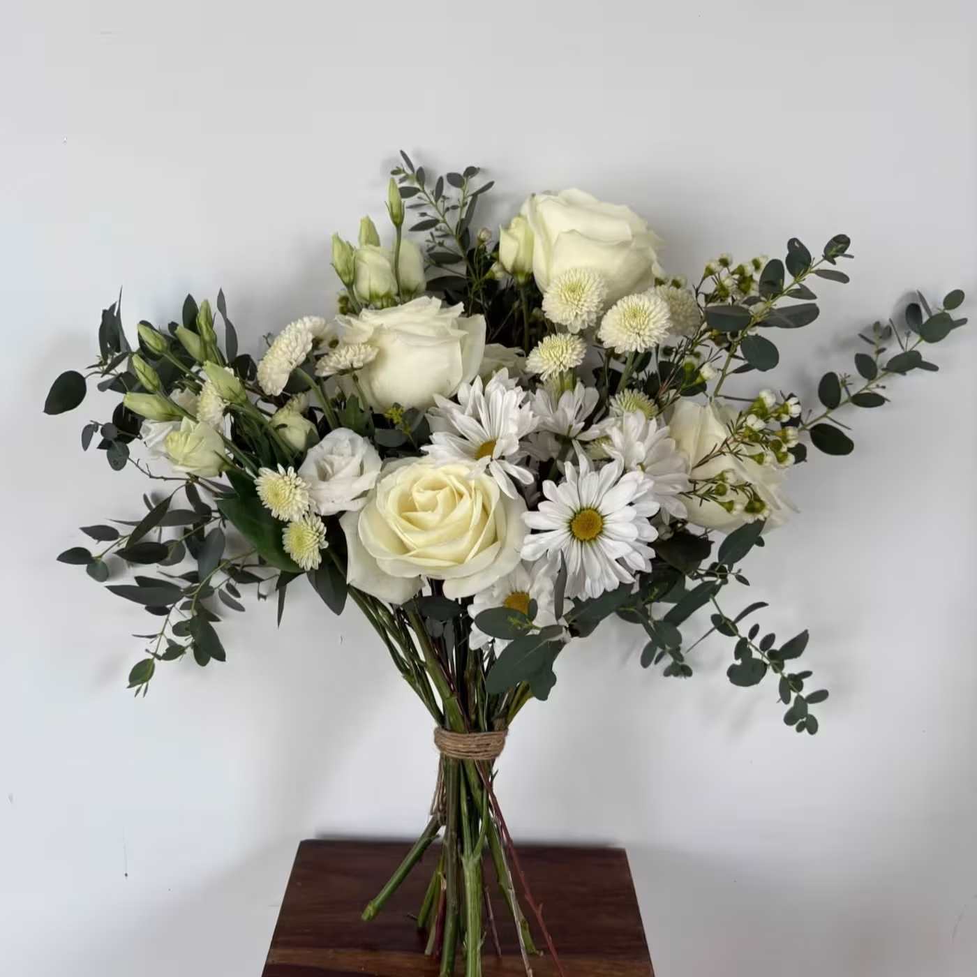 White with Greens Standard Handtied Bouquet White with Greens Standard Handtied Bouquet - A mix of designer’s choice white blooms of Mum, Rose, Alstroemeria, Hydrangea nestled in assorted greens and Eucalyptus