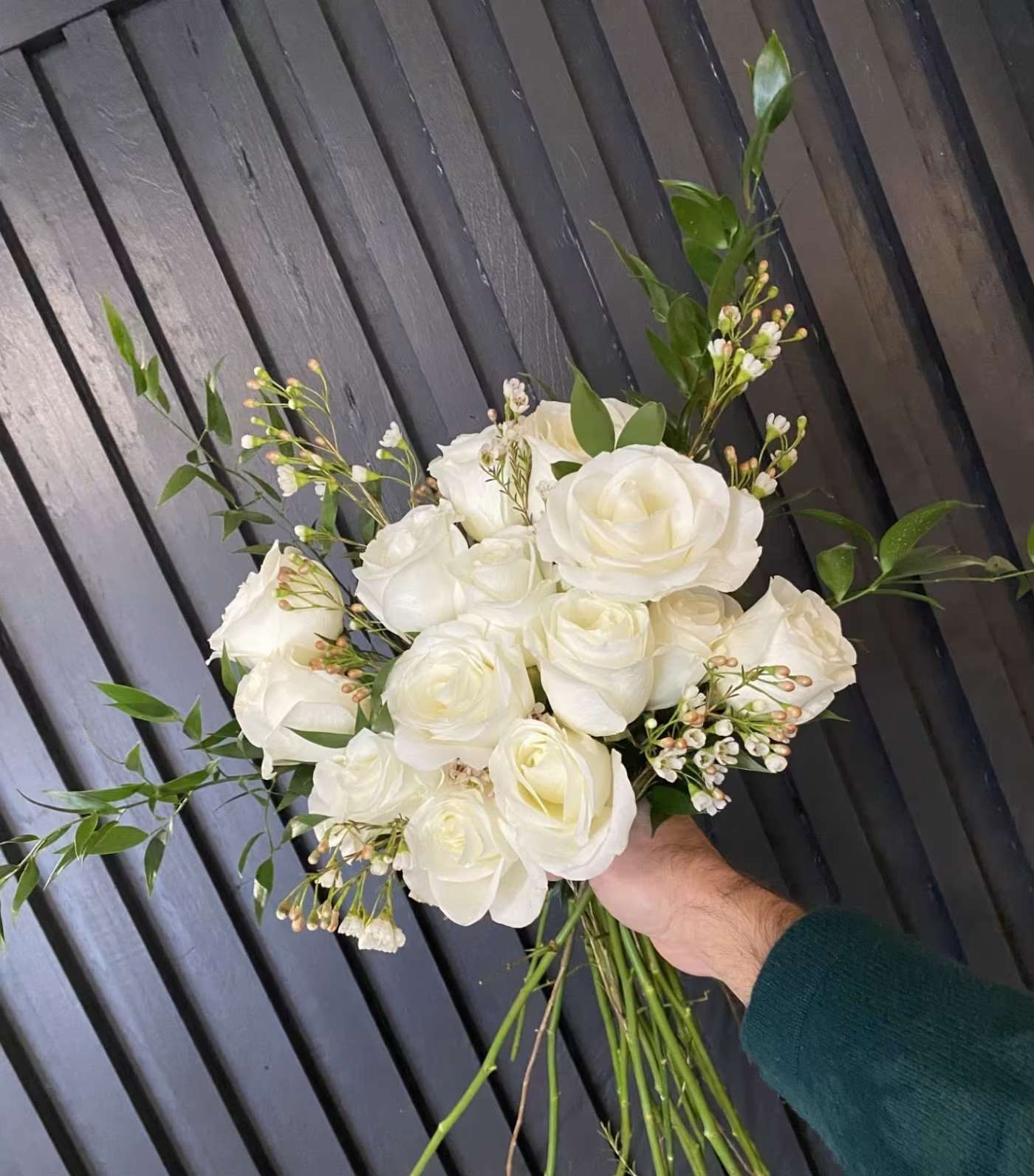 Handtied Dozen White Roses Handtied Dozen White Roses - A bouquet of 12 long stemmed roses, in classic white, with sprigs of assorted greenery and Eucalyptus and a touch of Wax Flower filler.