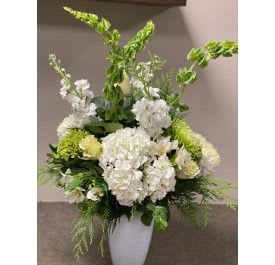 Winter Storm - Winter white arrangement including winter greens, snap dragons, roses, hydrangea and more.
