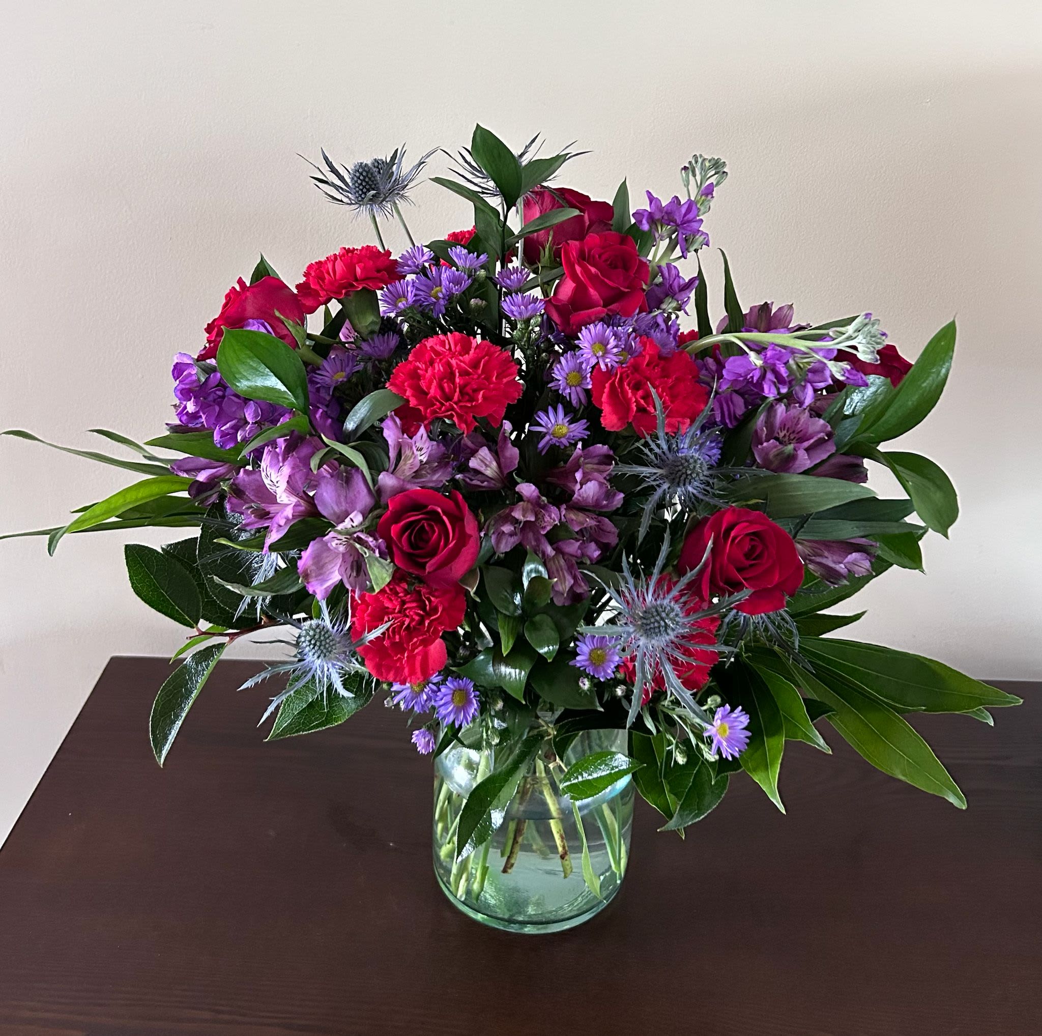 Violet Passion - An explosion of color and elegance. Red roses and purple blooms intertwine in a vibrant design that expresses passion, strength, and sophistication. Perfect for surprising, thanking, or falling in love. Clear Glass All Occasion  Place your Order Online Monday to Saturday before 1:00 p.m. (E.T.) for same-day delivery. “Orders received after hours will be delivered the next business day”. Check our coverage area. Occasionally, flowers and/or container substitutions happen due to weather, seasonality, and market conditions, which may affect availability. If this is the case with the gift you’ve selected, we will ensure that your arrangement's style, theme, and color scheme are preserved and will only substitute items of equal value or higher value.  CARE INSTRUCTIONS Keep the flower arrangement hydrated with natural water and change the water every two days. Do not spray any cleaning product on the flower arrangement. Do not place heavy objects directly on the flower arrangement. Keep flower arrangements out of direct sunlight and extreme heat.