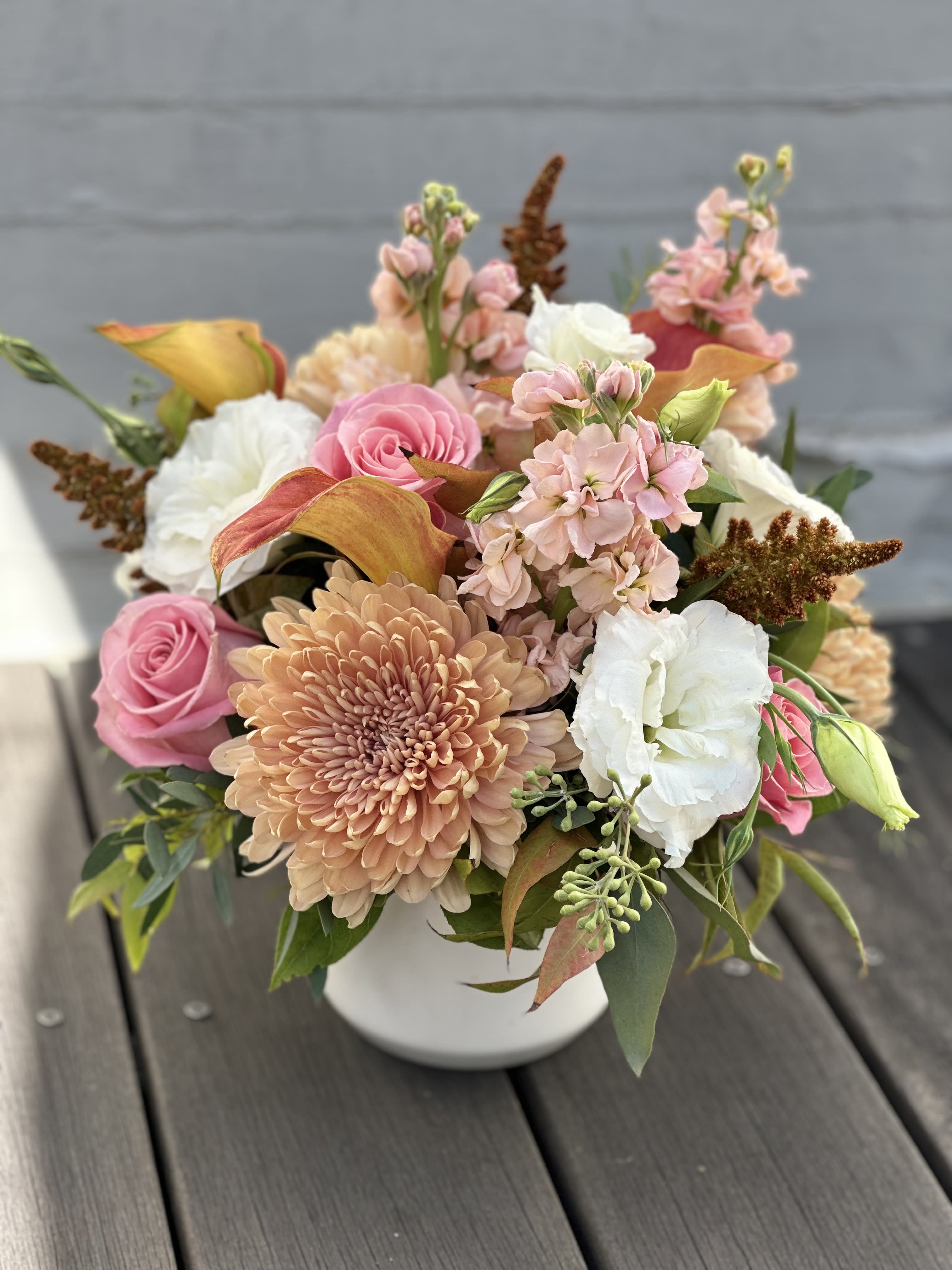 Pink Spice - A beautiful, seasonal bouquet of mums, pale pink roses, lisianthus, snap dragons, and fall foliage. Presented in a keepsake white ceramic pot.